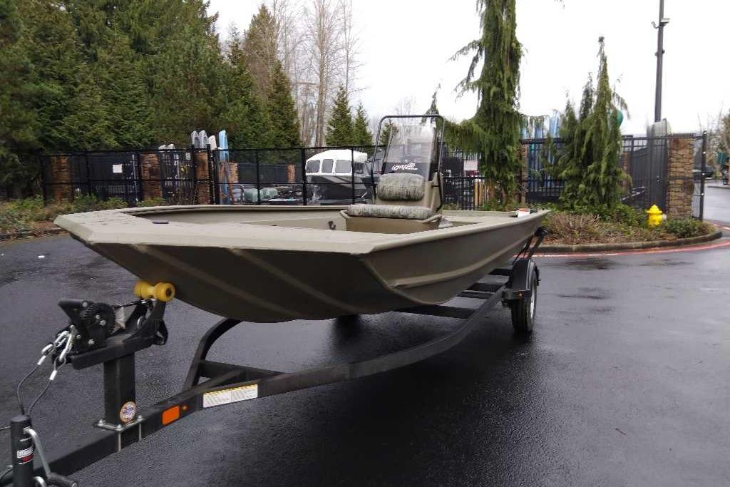 2026 Tracker Grizzly 1860 CC boat on trailer, parked outdoors.