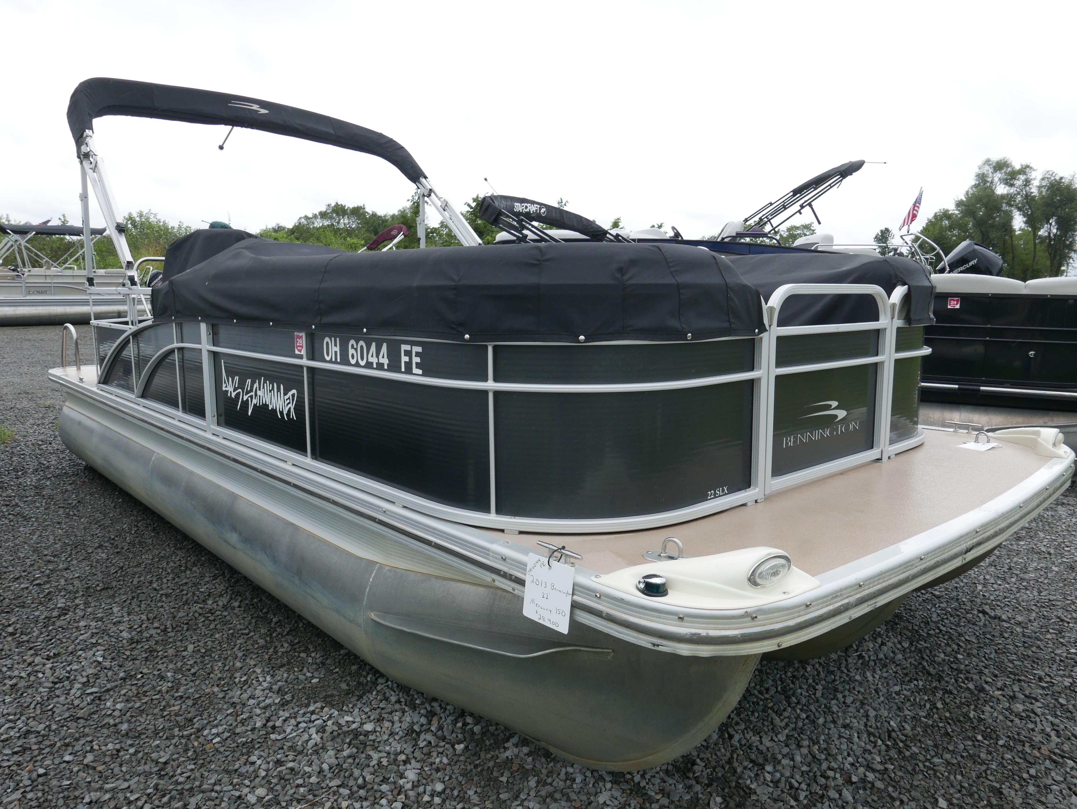 2013 Bennington 22SLX pontoon boat with black cover, parked on gravel.
