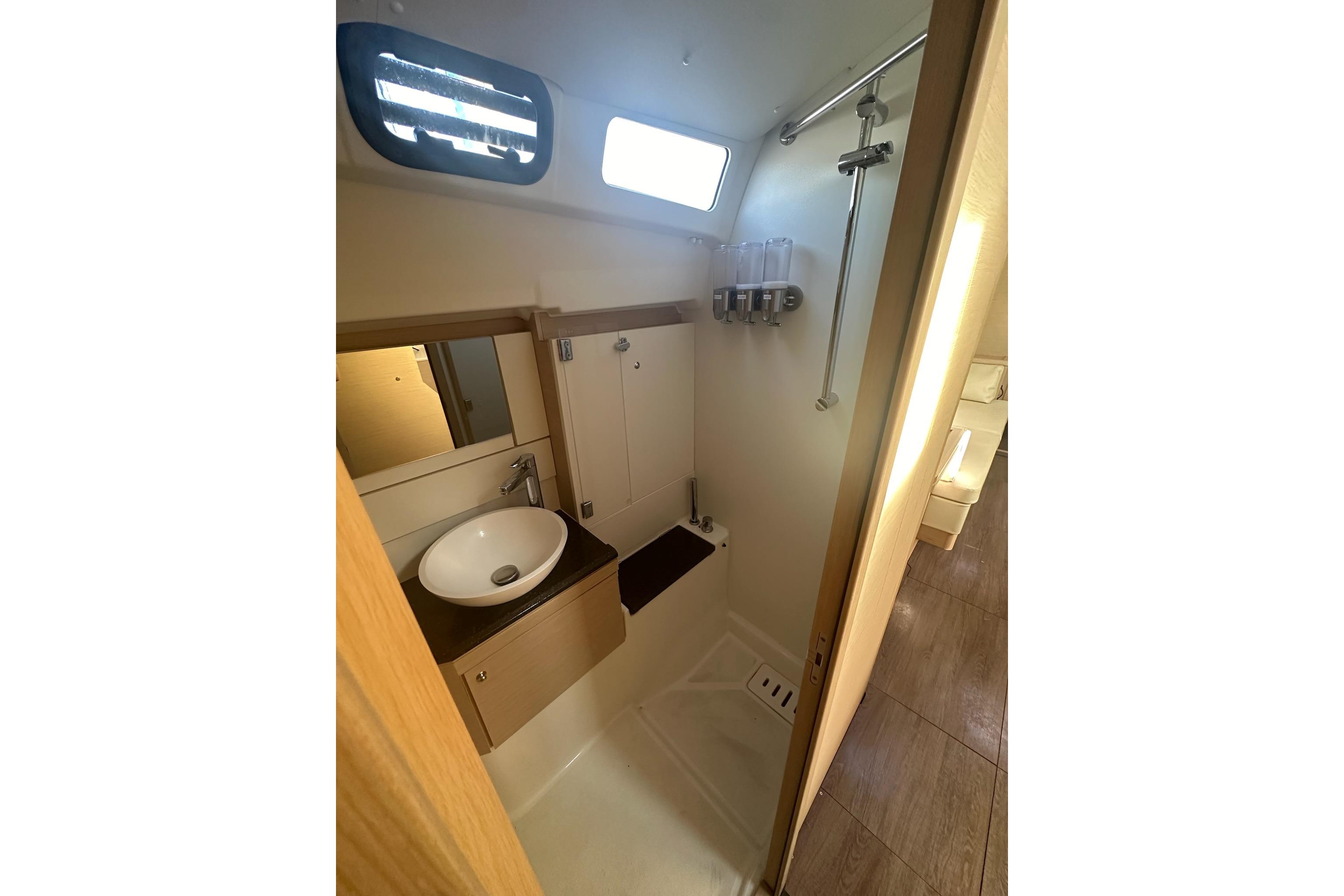 Modern bathroom interior of 2018 Jeanneau 51 yacht with sink and shower.