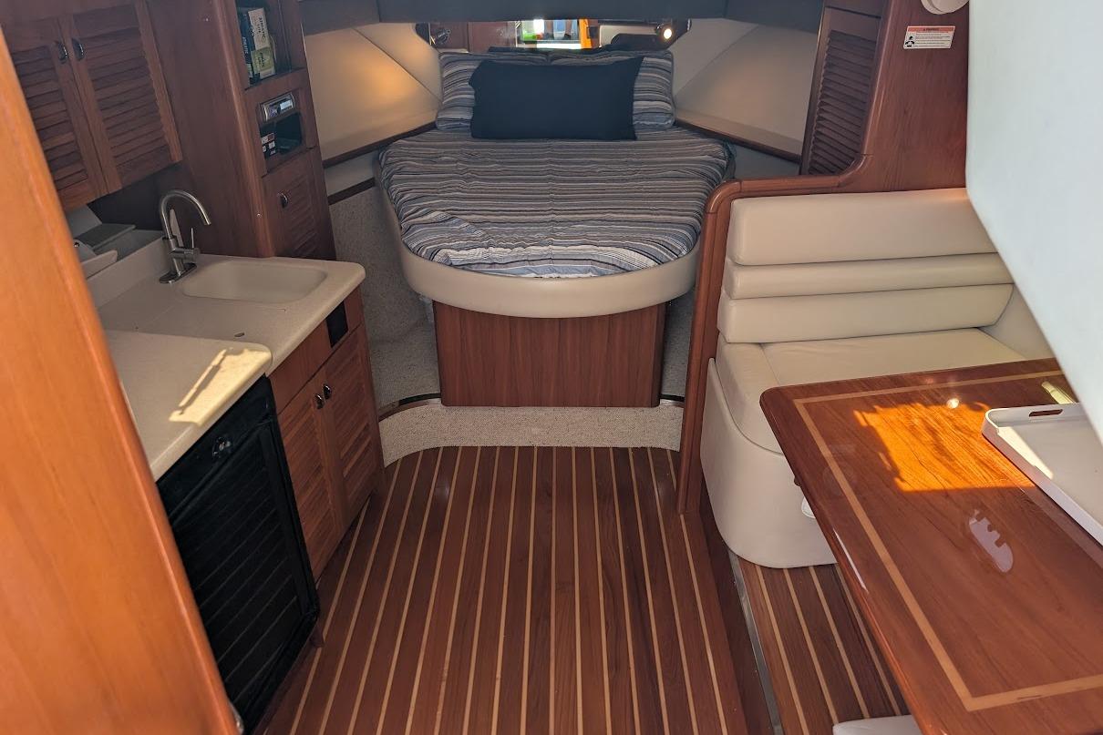 Interior of 2000 Pursuit 3400 Express boat with cozy cabin and wooden finishes.