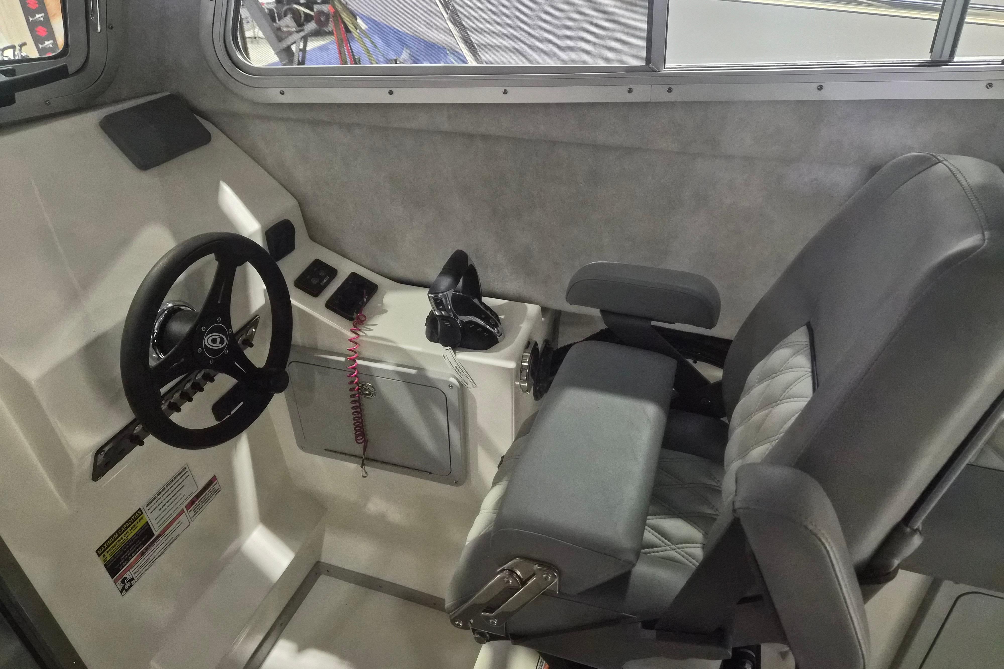 Interior of 2026 Defiance Admiral 260 EX boat, featuring steering wheel and captain's chair.