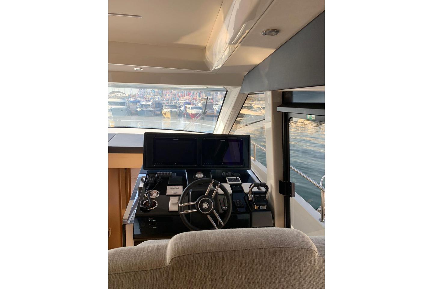 Interior helm of 2022 Greenline 45 Coupe yacht with modern navigation equipment.