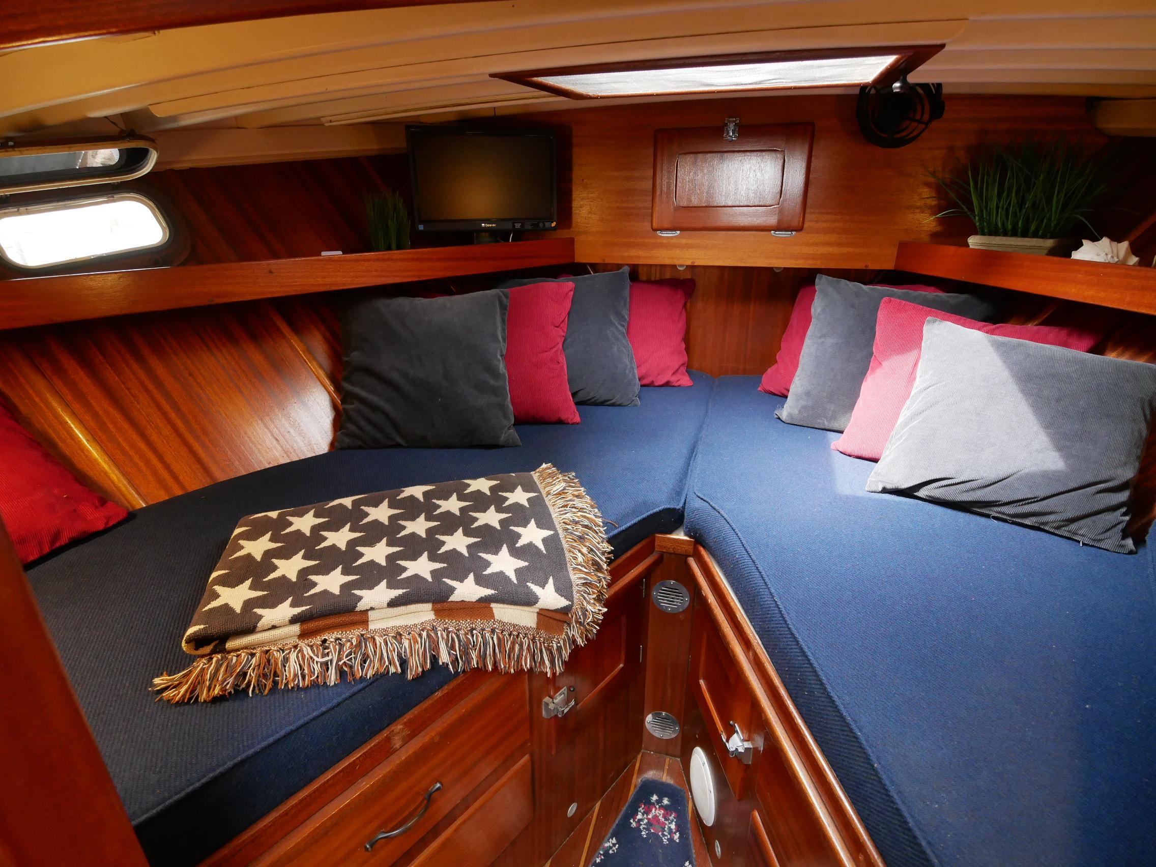 Cozy cabin interior of 1964 Egg Harbor 37 Convertible Sedan with blue and red cushions.