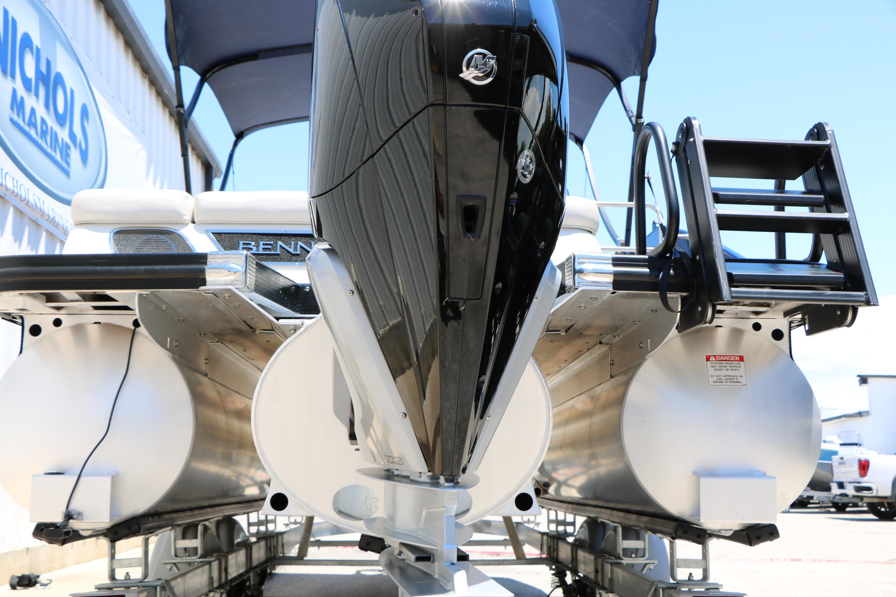 2024 Bennington 23 RX Swingback pontoon boat with powerful outboard motor, docked at Nichols Marine.