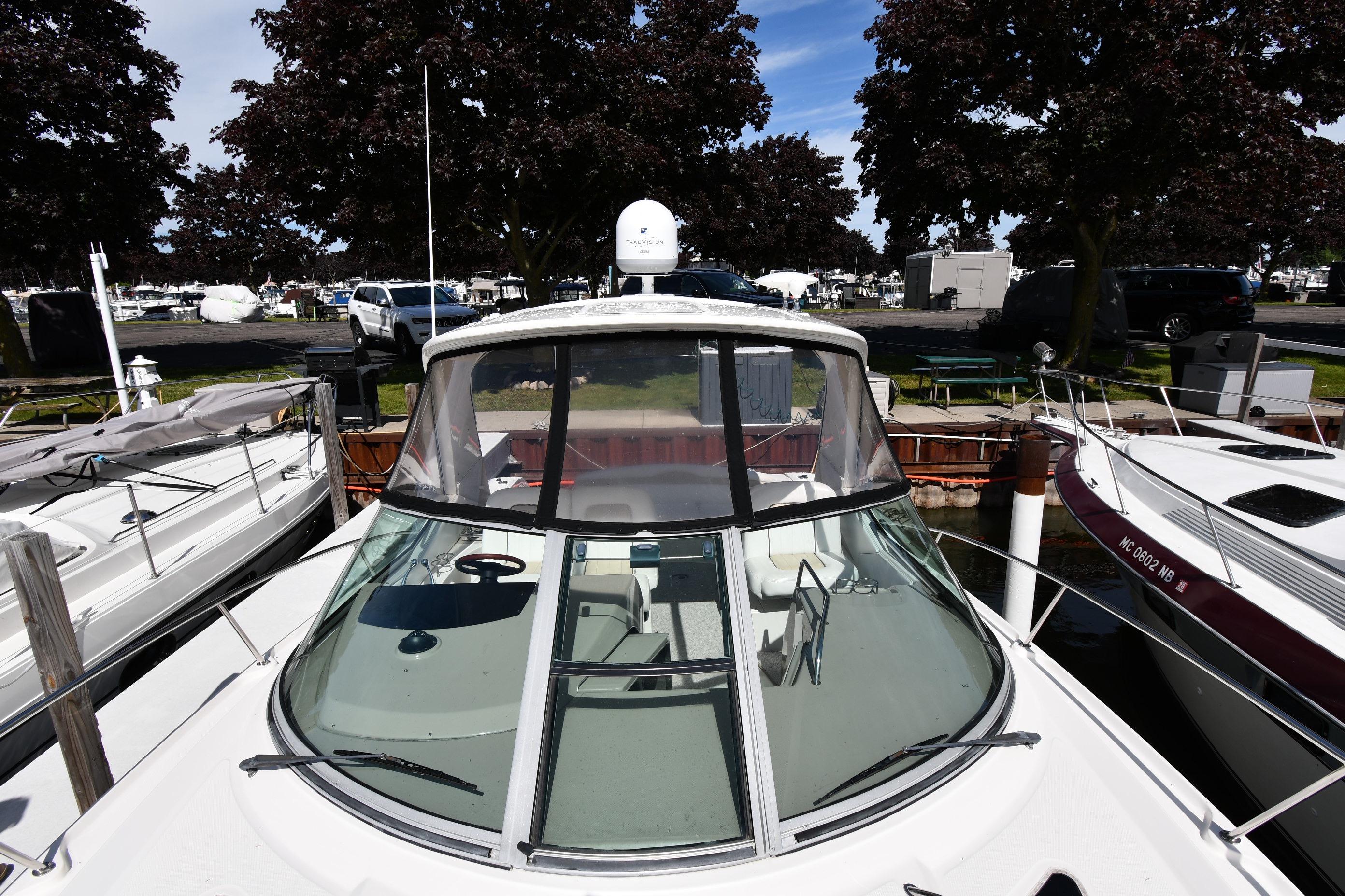 2008 Sea Ray Sundancer 350 docked at marina, surrounded by trees and parked vehicles.