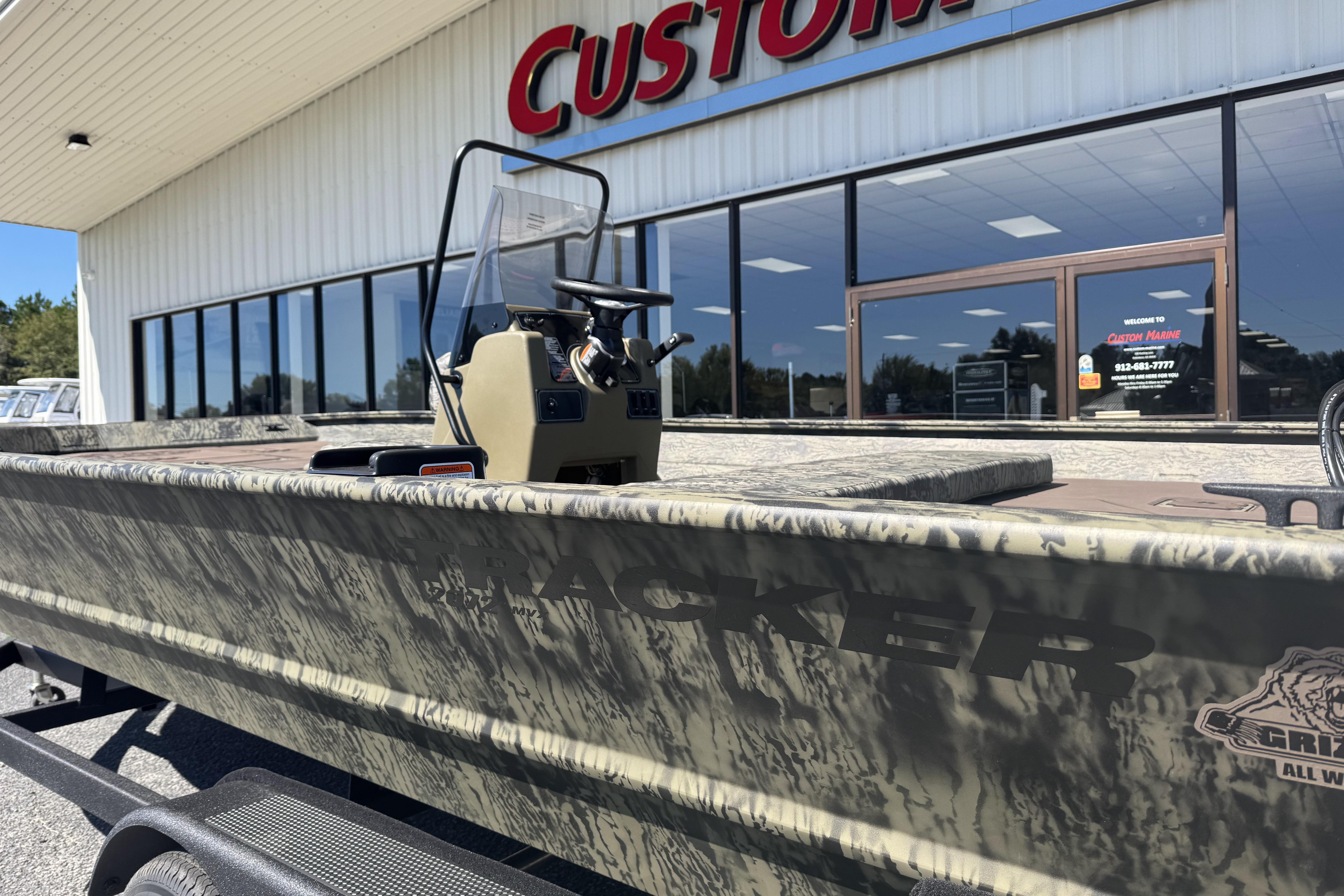2026 Tracker Grizzly 2072 CC boat outside Custom Marine store.