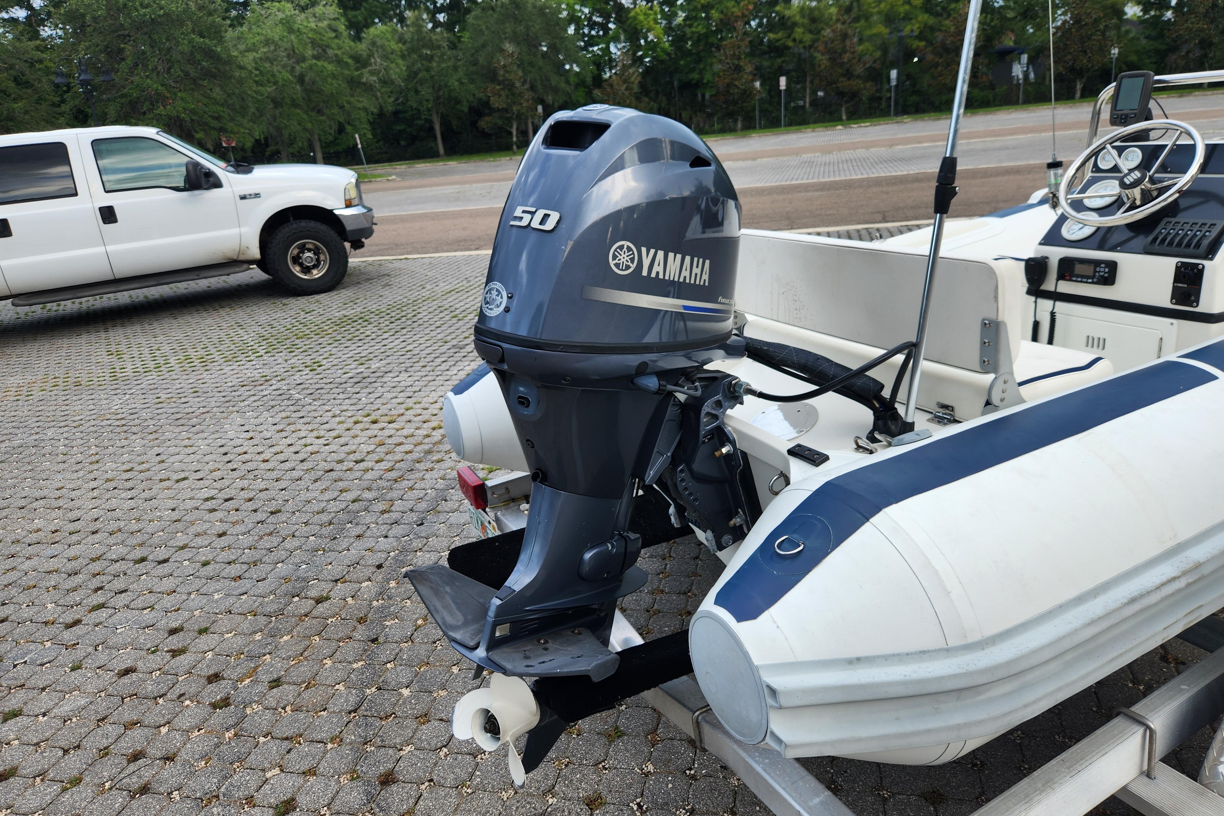 Novurania DL 400 boat with Yamaha 50 outboard motor, parked on paved area.
