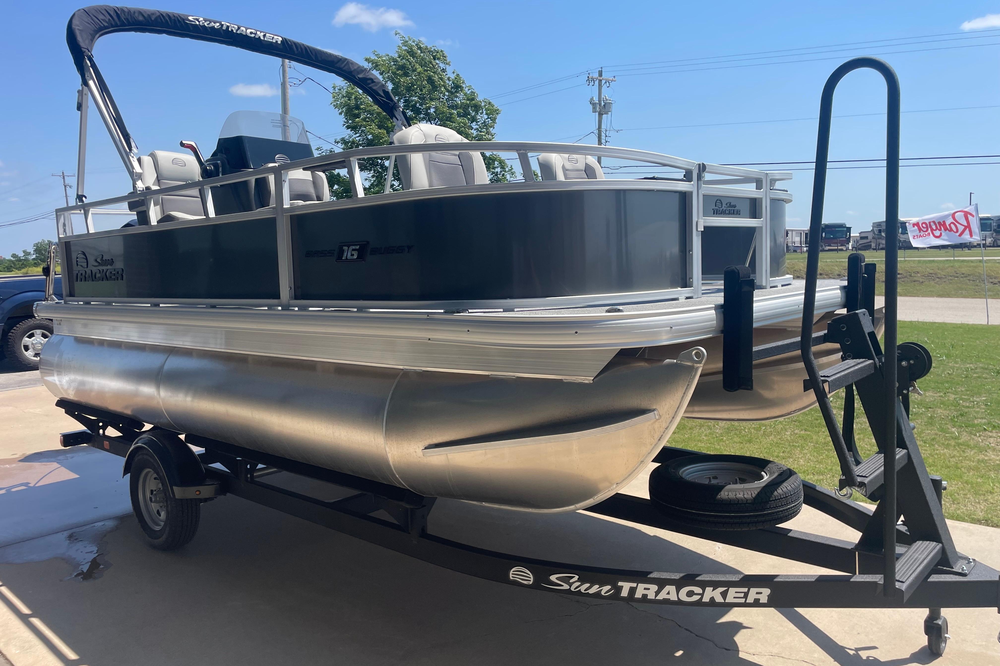 2026 Sun Tracker Bass Buggy 16 XL Select pontoon boat on trailer, outdoors.