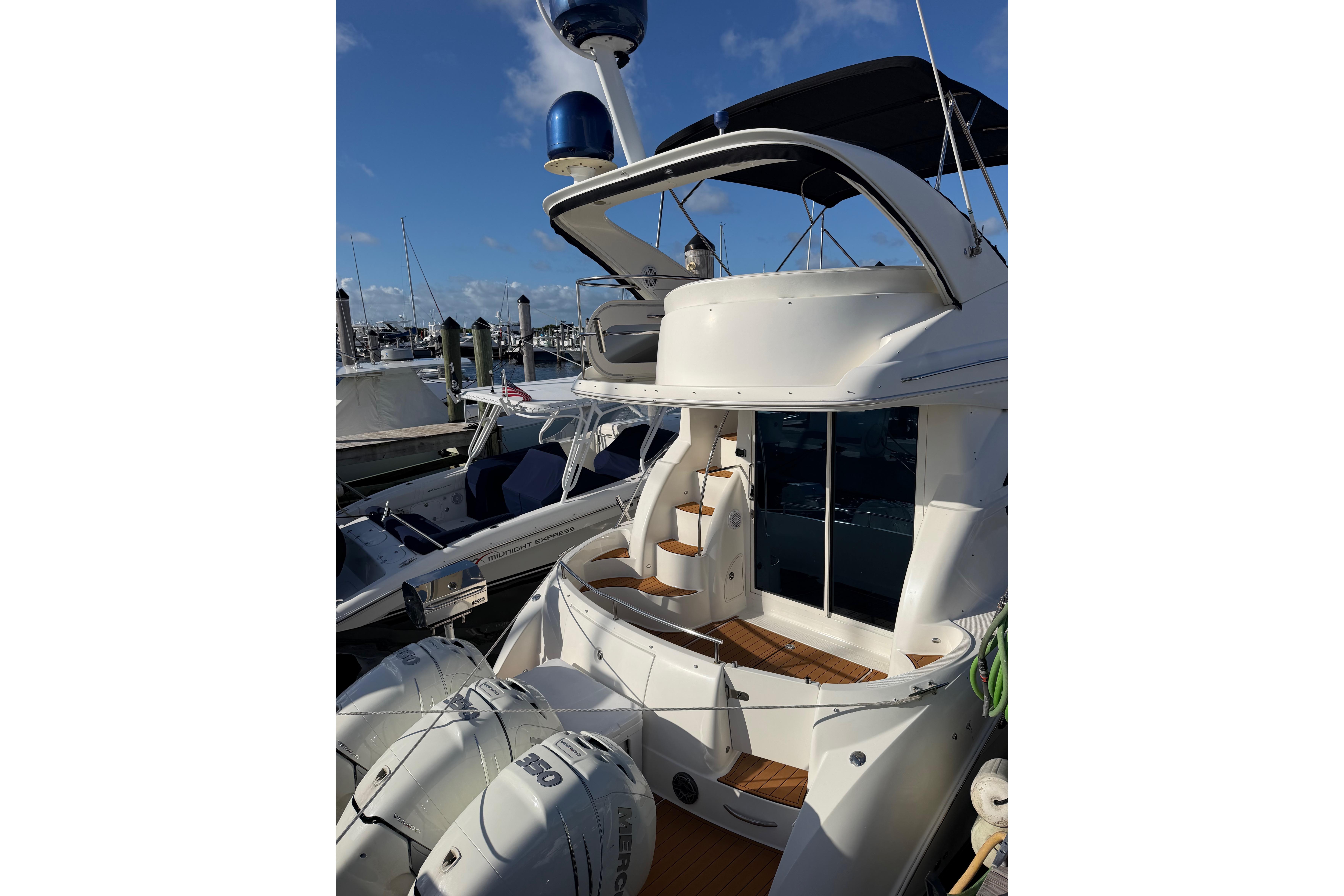 2006 Meridian 341 Sedan yacht docked at marina under clear blue sky.