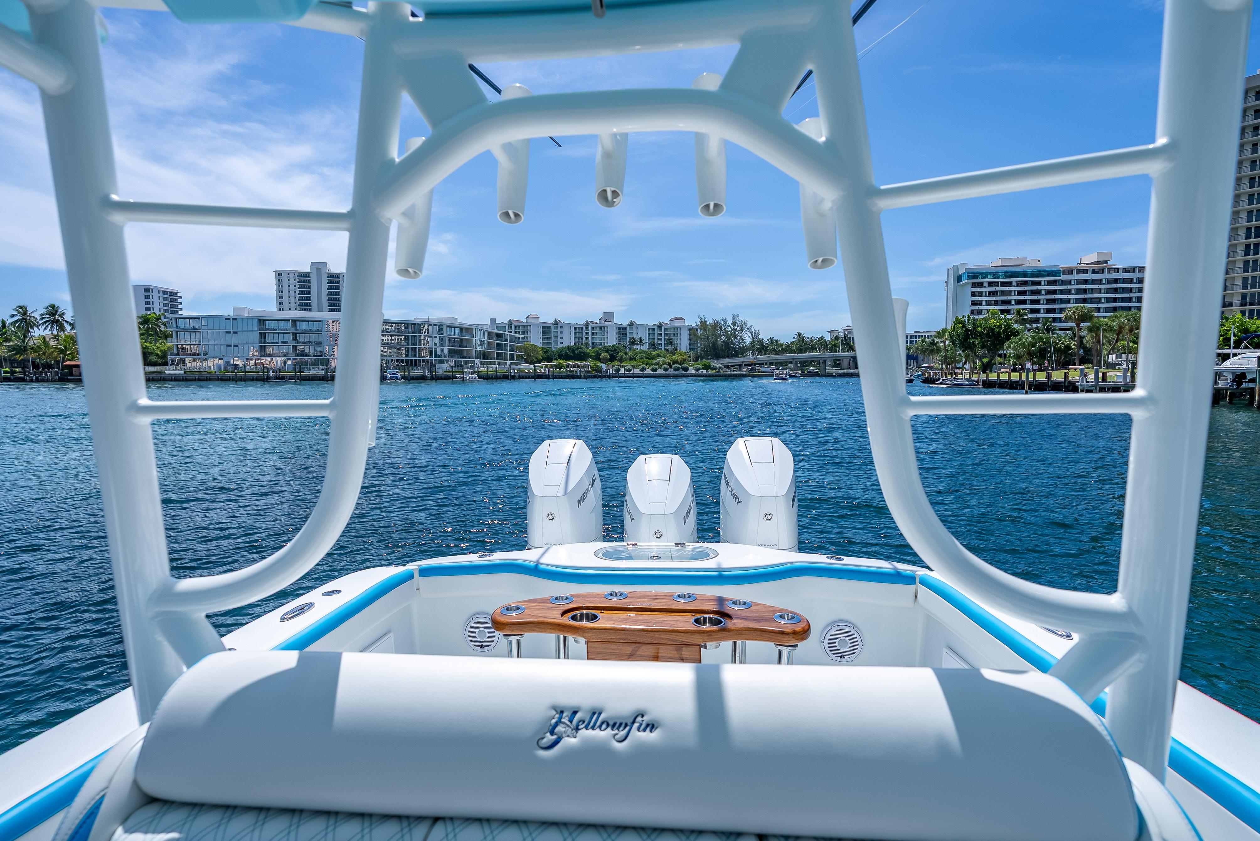 2016 Yellowfin 39 Offshore boat with triple engines, scenic waterfront view, and modern cityscape backdrop.