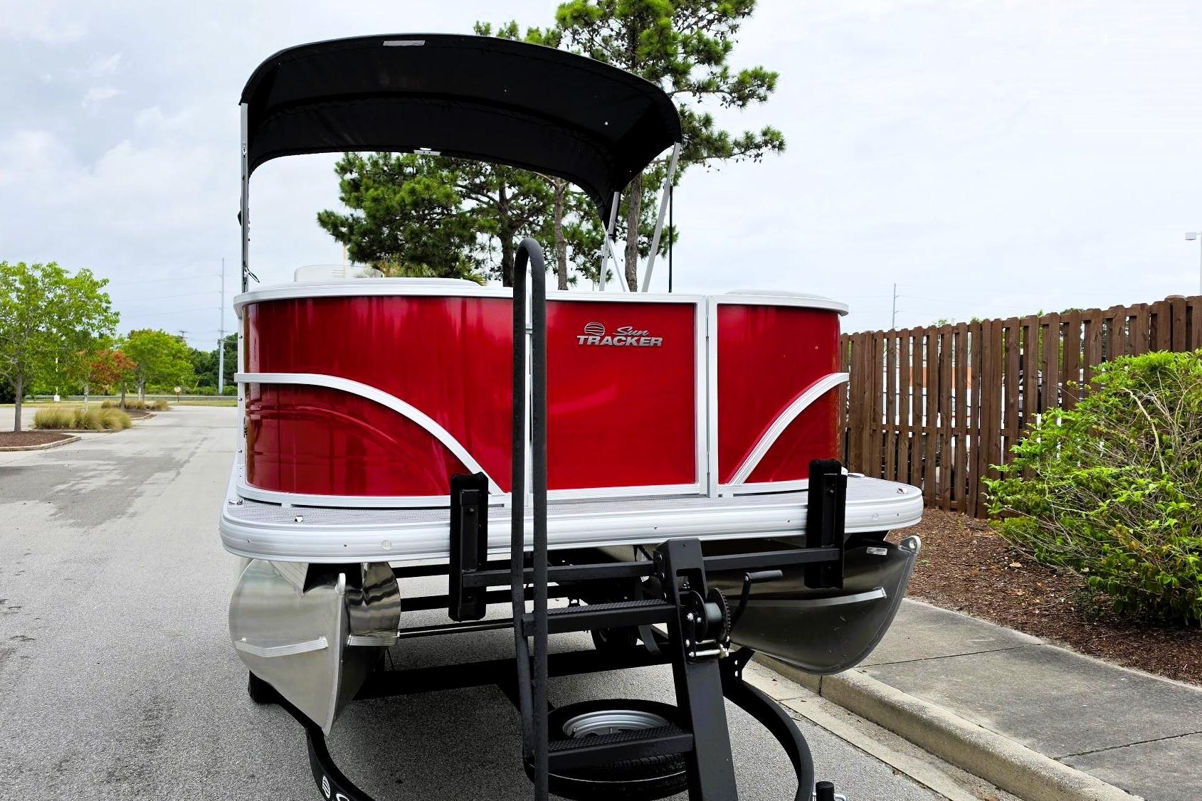 2026 Sun Tracker Party Barge 16 DLX pontoon boat on trailer, parked outdoors.