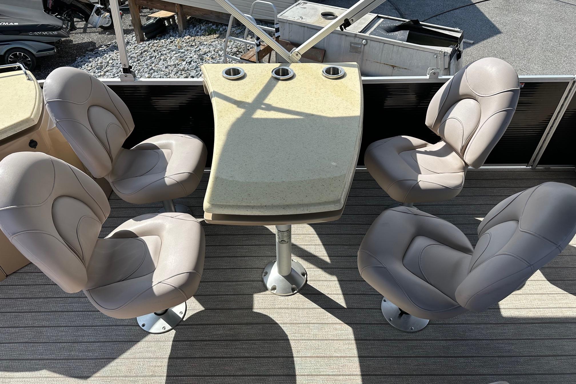 2017 Bennington 22 GPD boat interior with beige seating and table, featuring cup holders.
