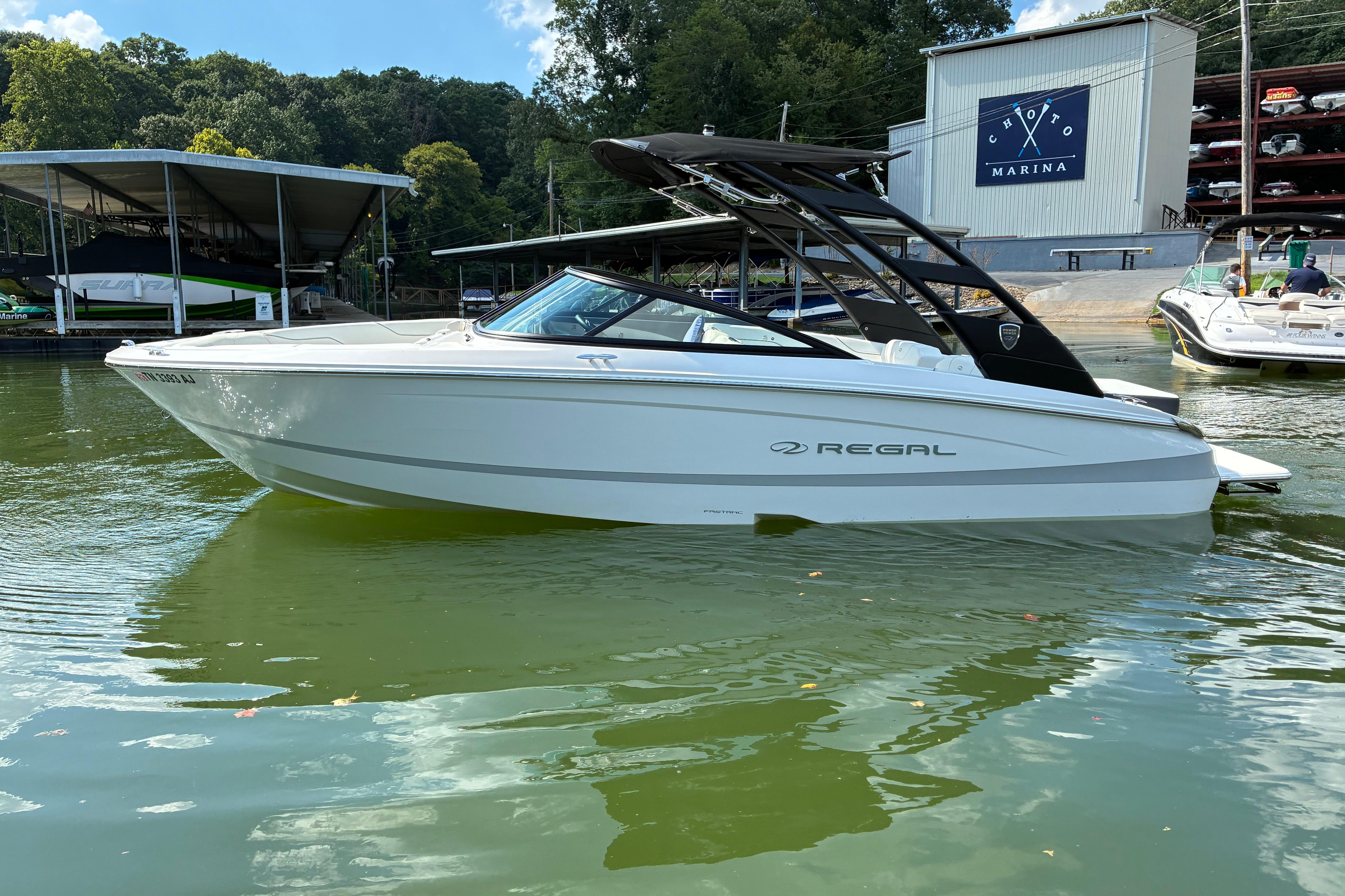2025 Regal LS2 boat docked at marina, surrounded by lush greenery and calm waters.