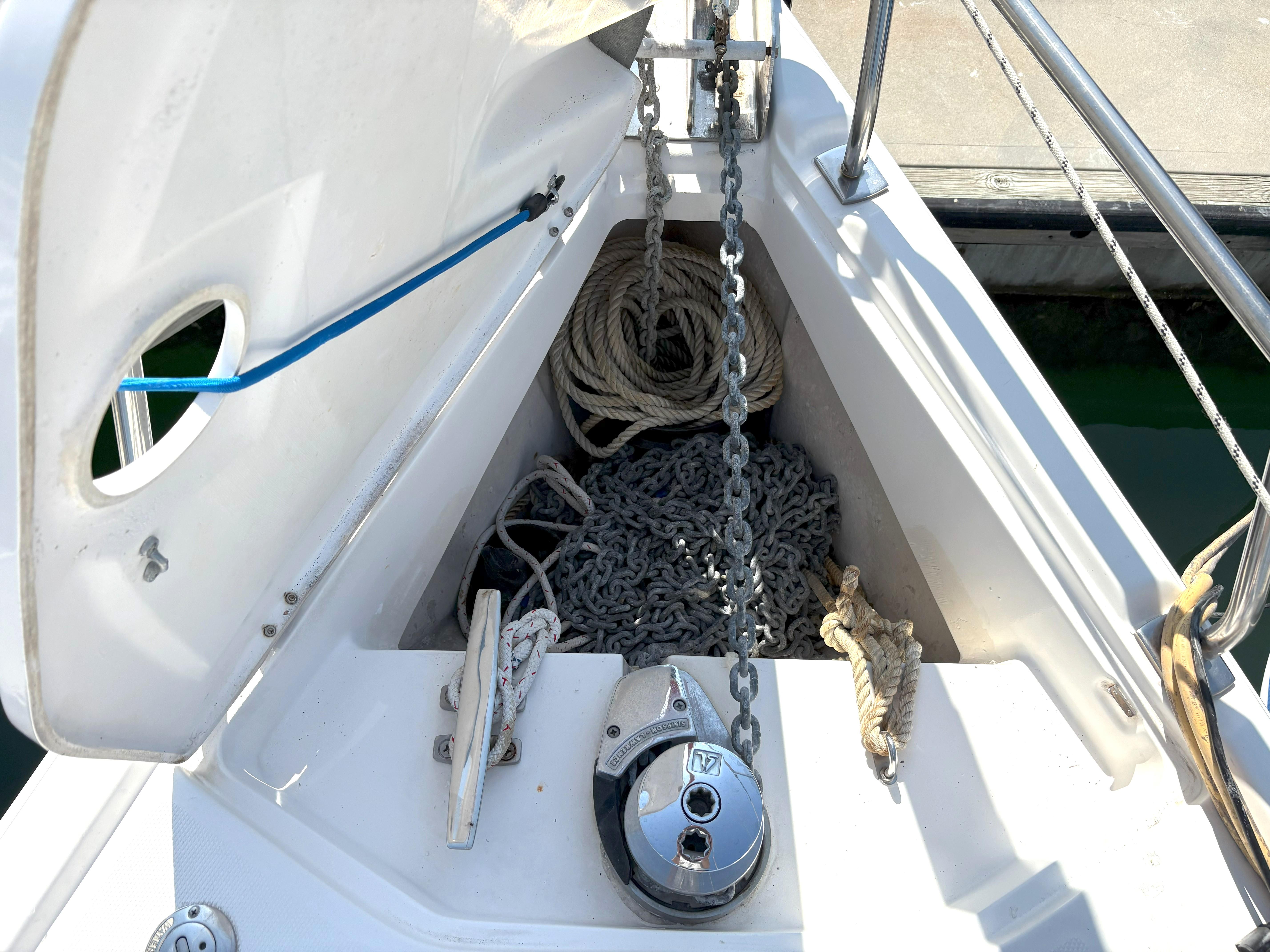 Anchor locker of a 2005 Hunter 38 sailboat with ropes and chains.