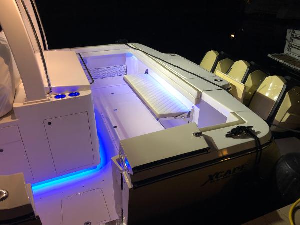 2019 Altima 38 Xcape boat with illuminated deck and seating area at night.