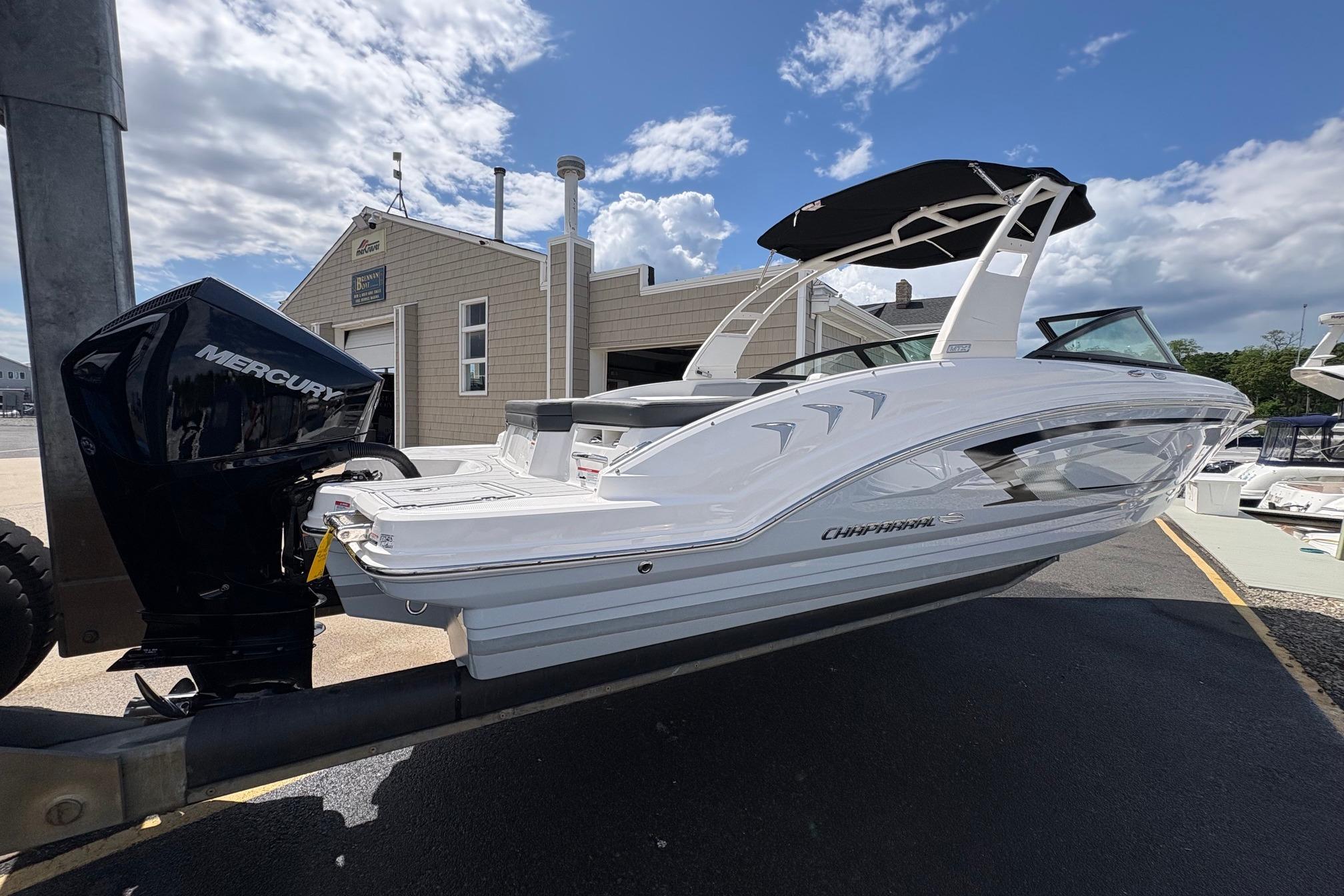 2026 Chaparral 23 SSi OB boat with Mercury outboard engine, docked under a blue sky.