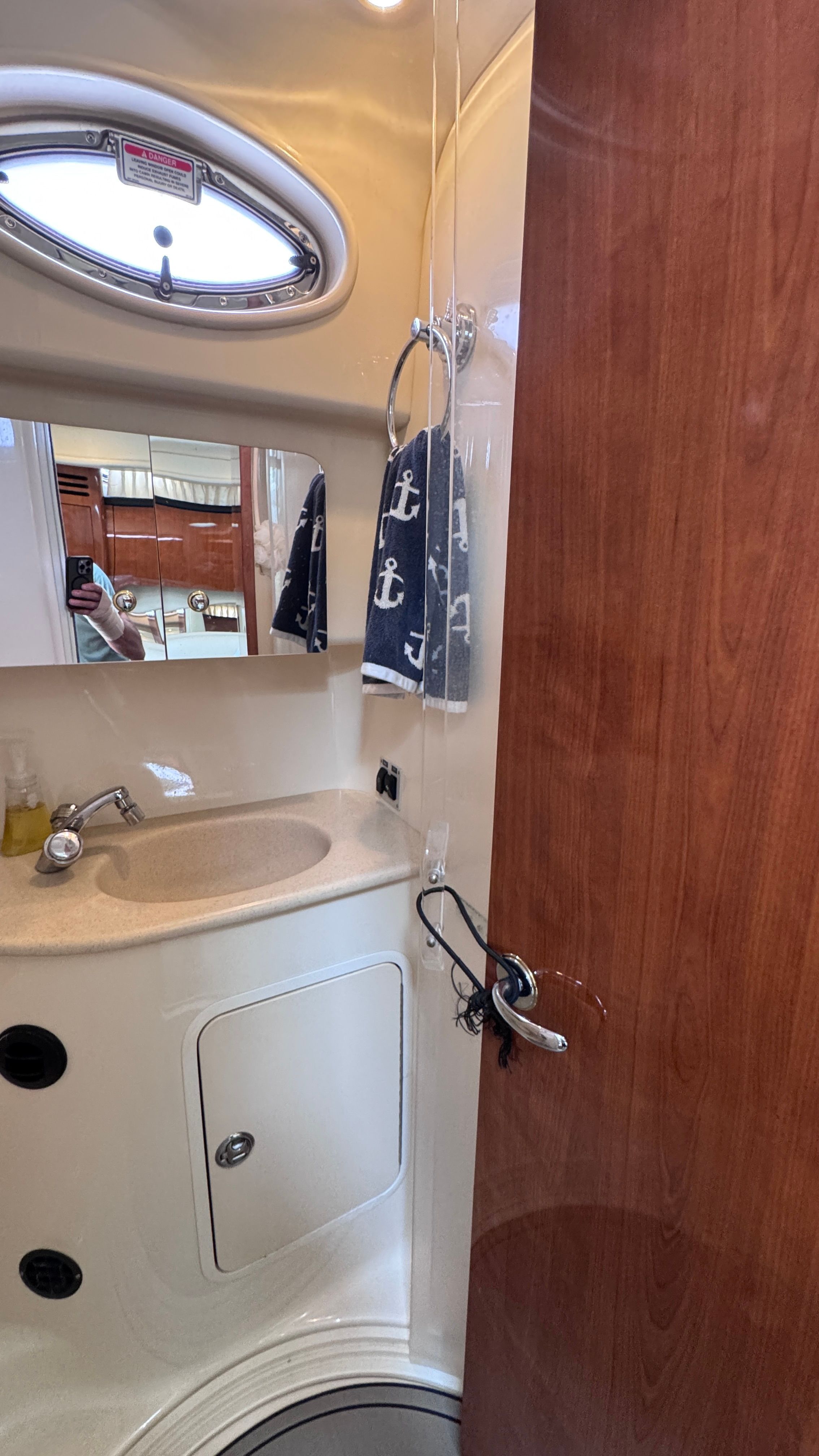 The image shows the bathroom of a 2003 Sea Ray 360 Sundancer. It features a sink, mirror, and porthole.