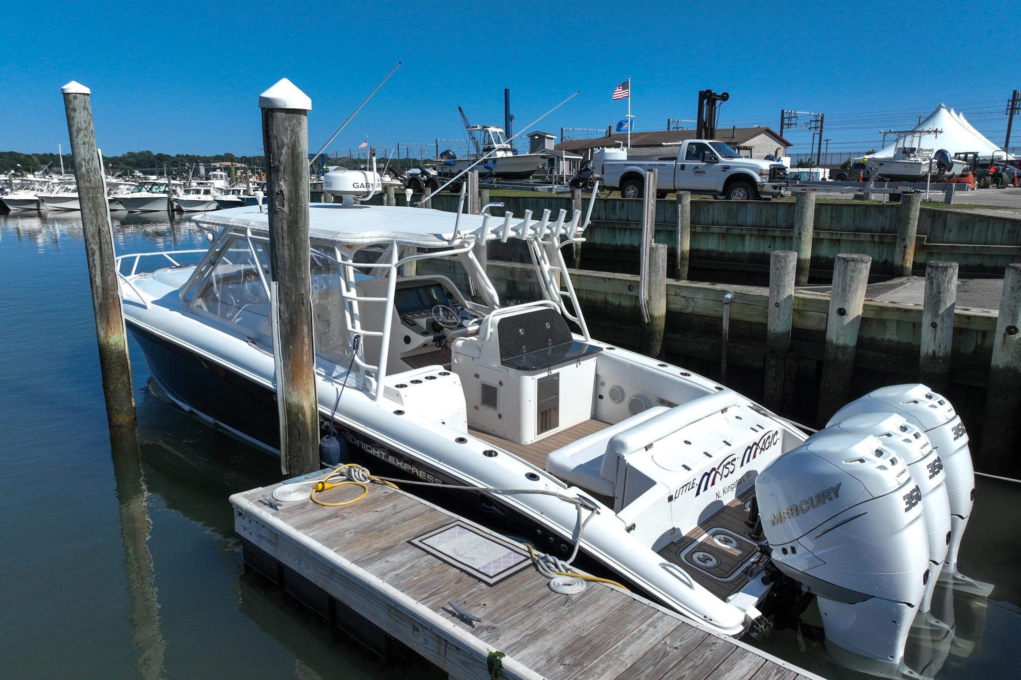 2007 Midnight Express 37 Cabin boat docked with triple Mercury engines.