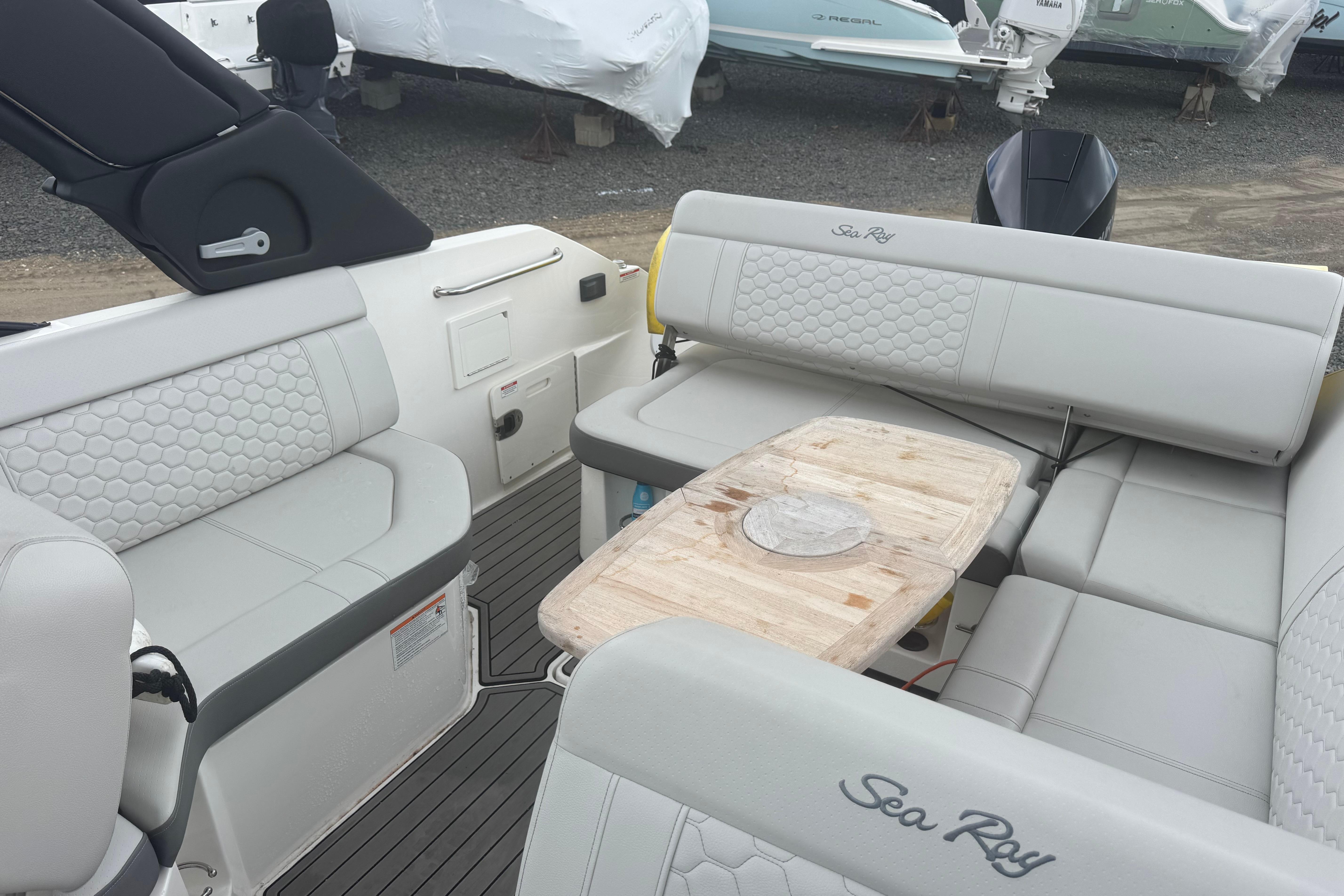 2024 Sea Ray SDX 250 Outboard interior with luxurious seating and wooden table.