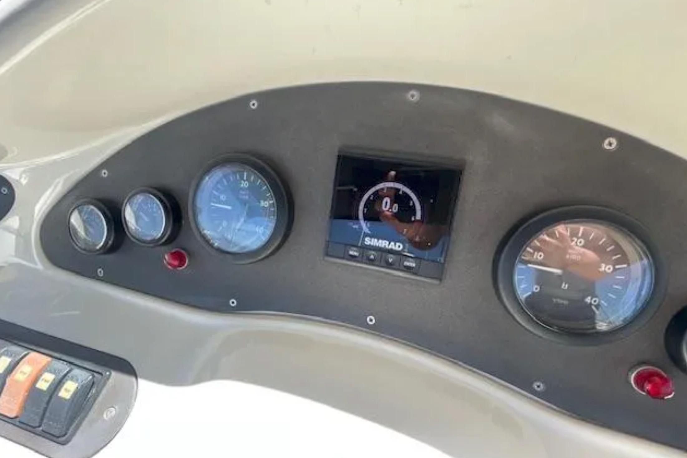 Dashboard of a 2004 Azimut 46 yacht with gauges and Simrad display.