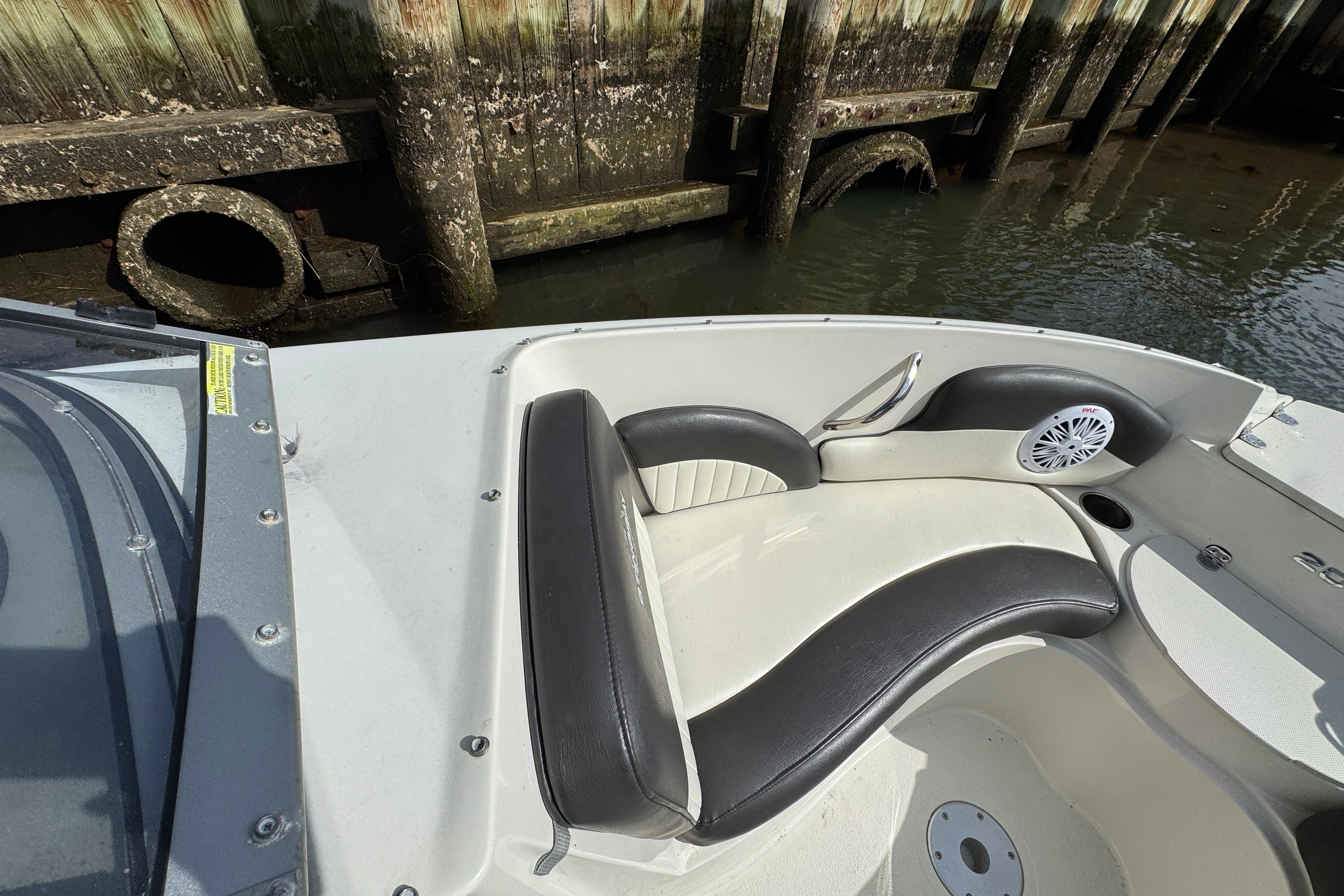 2019 Stingray 204 LR boat interior with black and white seating near a wooden dock.