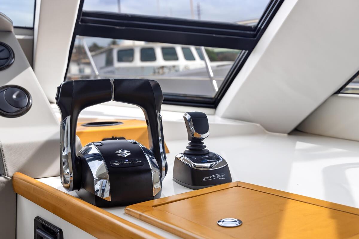 Control panel of 2023 ArrowCat 420 Flybridge with Suzuki throttle and Optimus joystick.