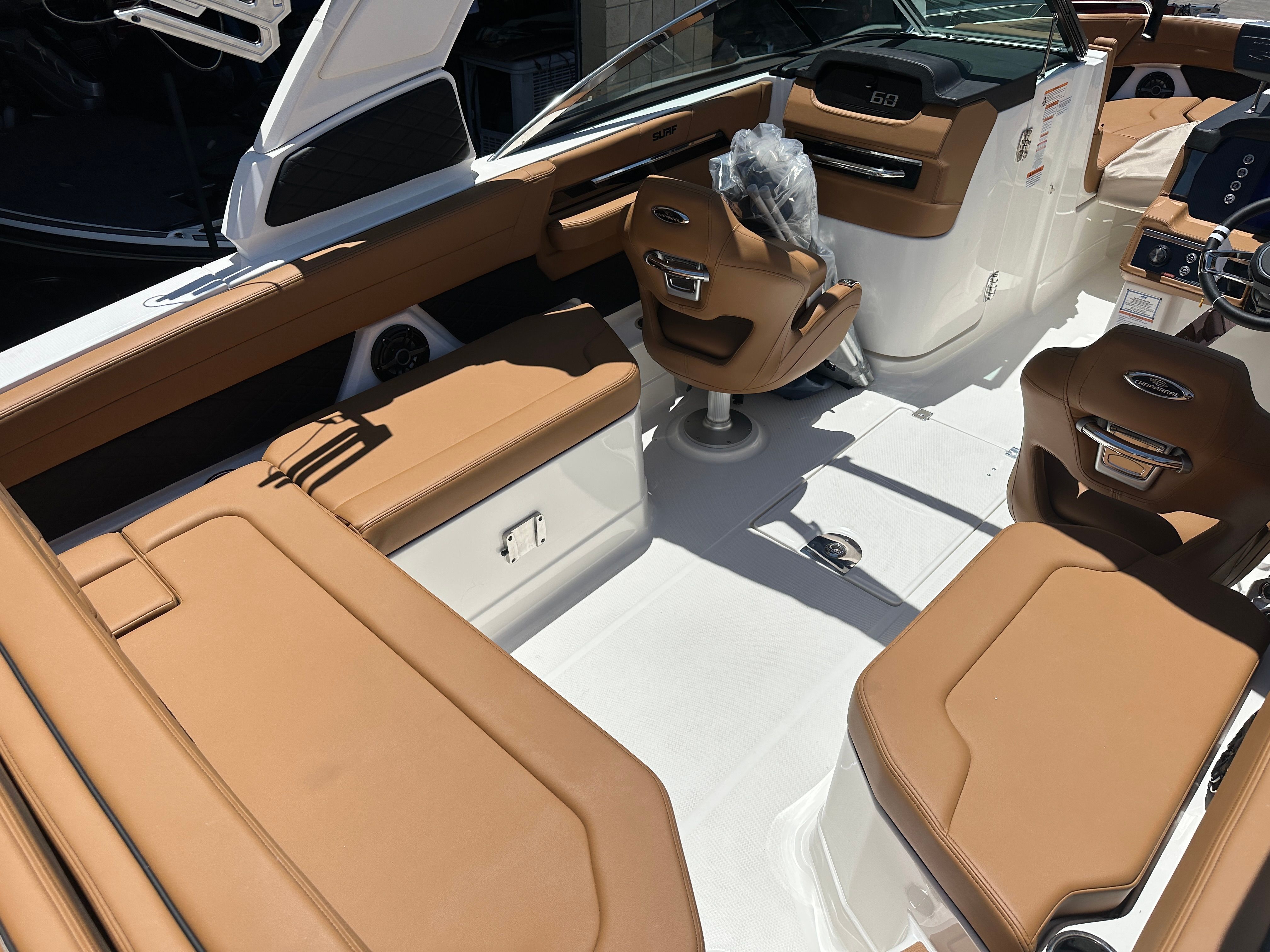 Interior of a Chaparral 26 Surf boat with brown leather seats and a modern dashboard.