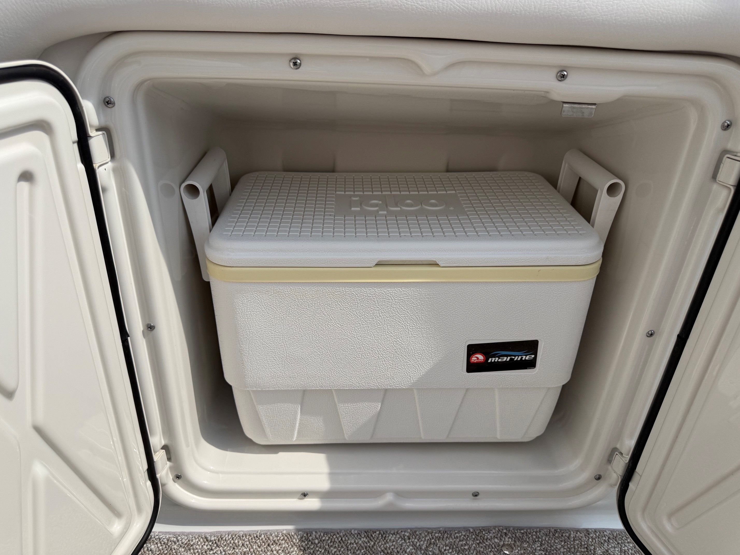 An Igloo cooler inside a storage compartment of a 2012 Crownline 252 EX boat.