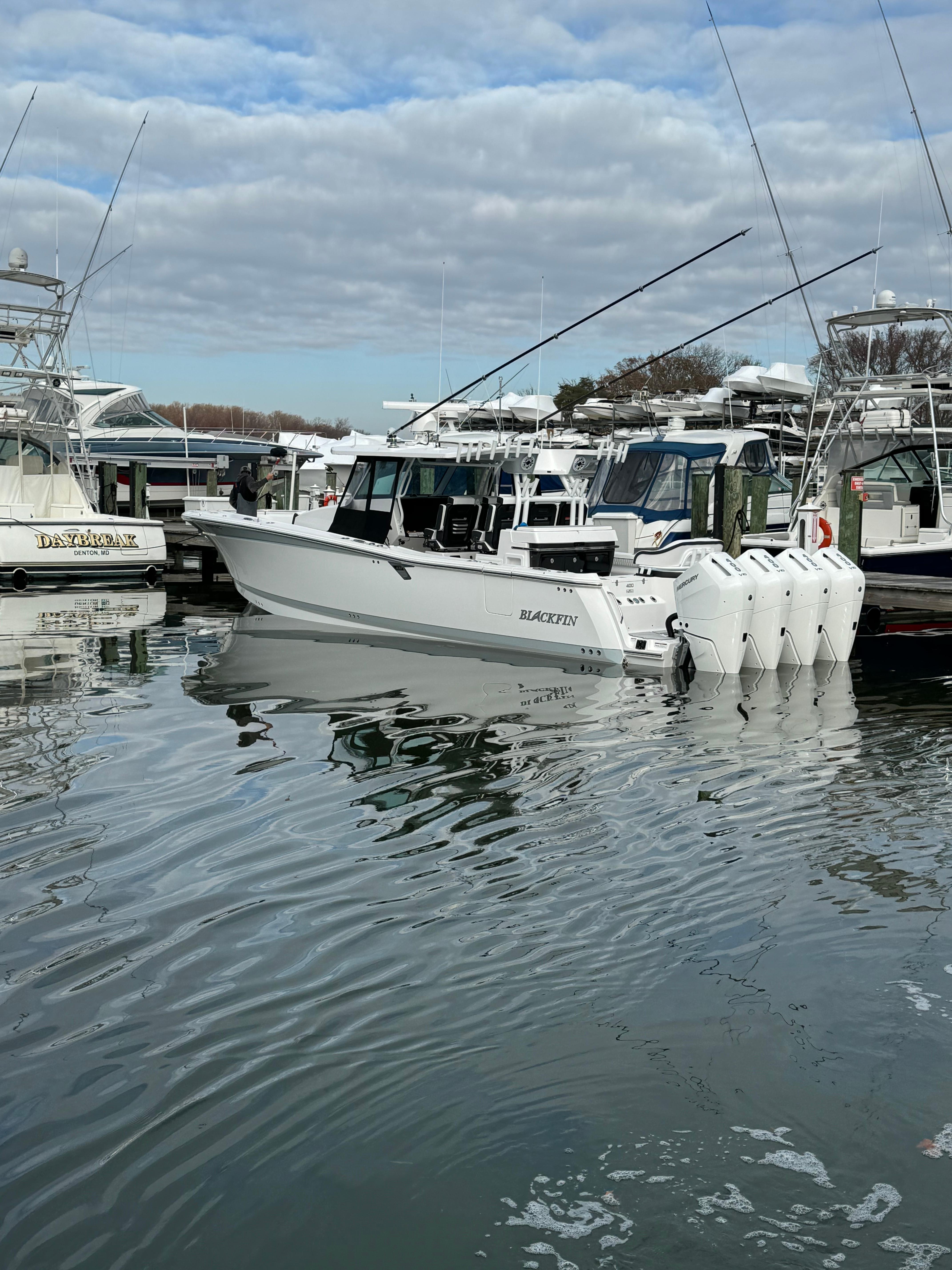 2025 Blackfin 400 CC boat docked in a marina with multiple outboard engines.