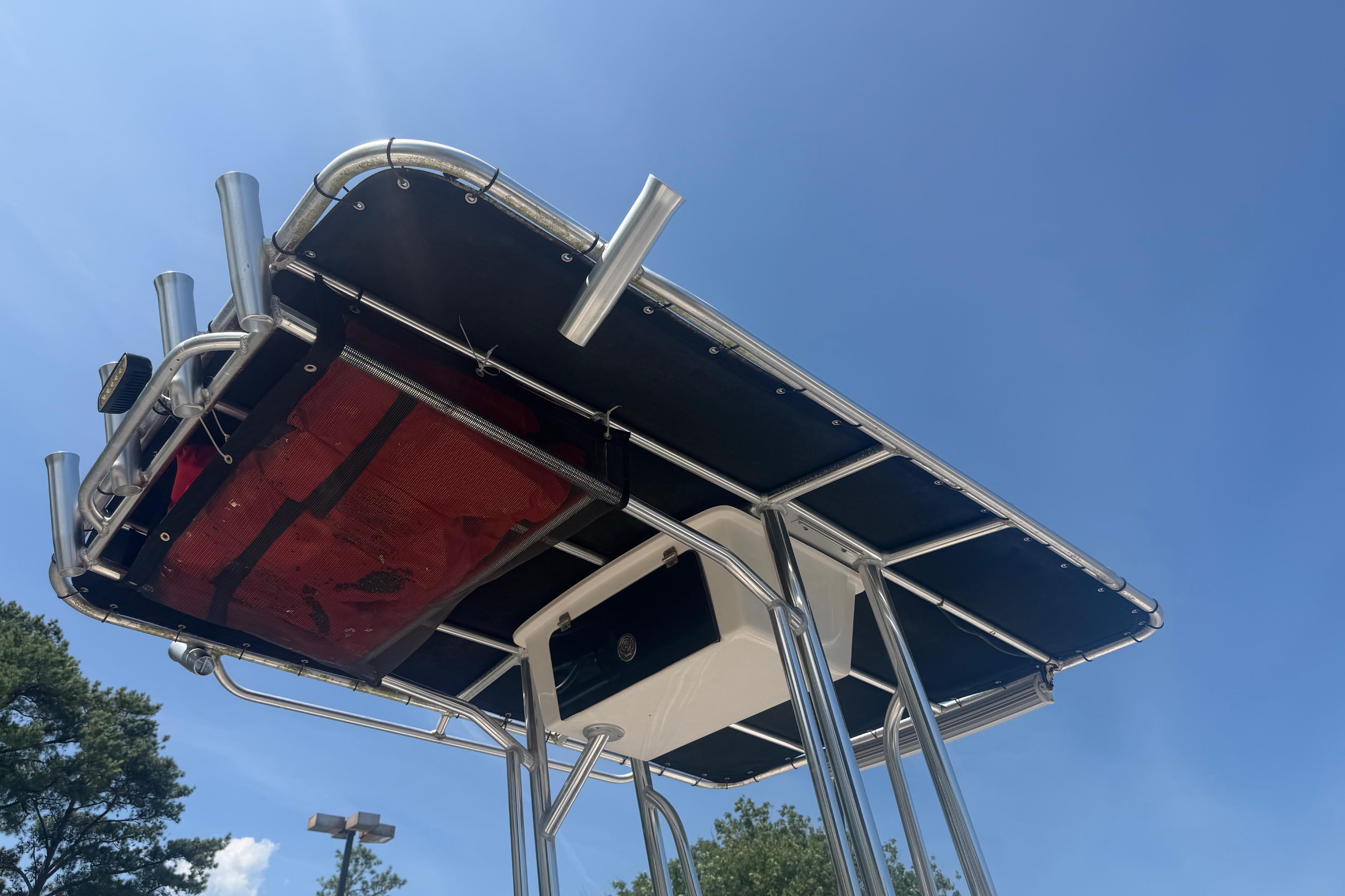 2019 Carolina Skiff 218 DLV boat T-top against clear blue sky.