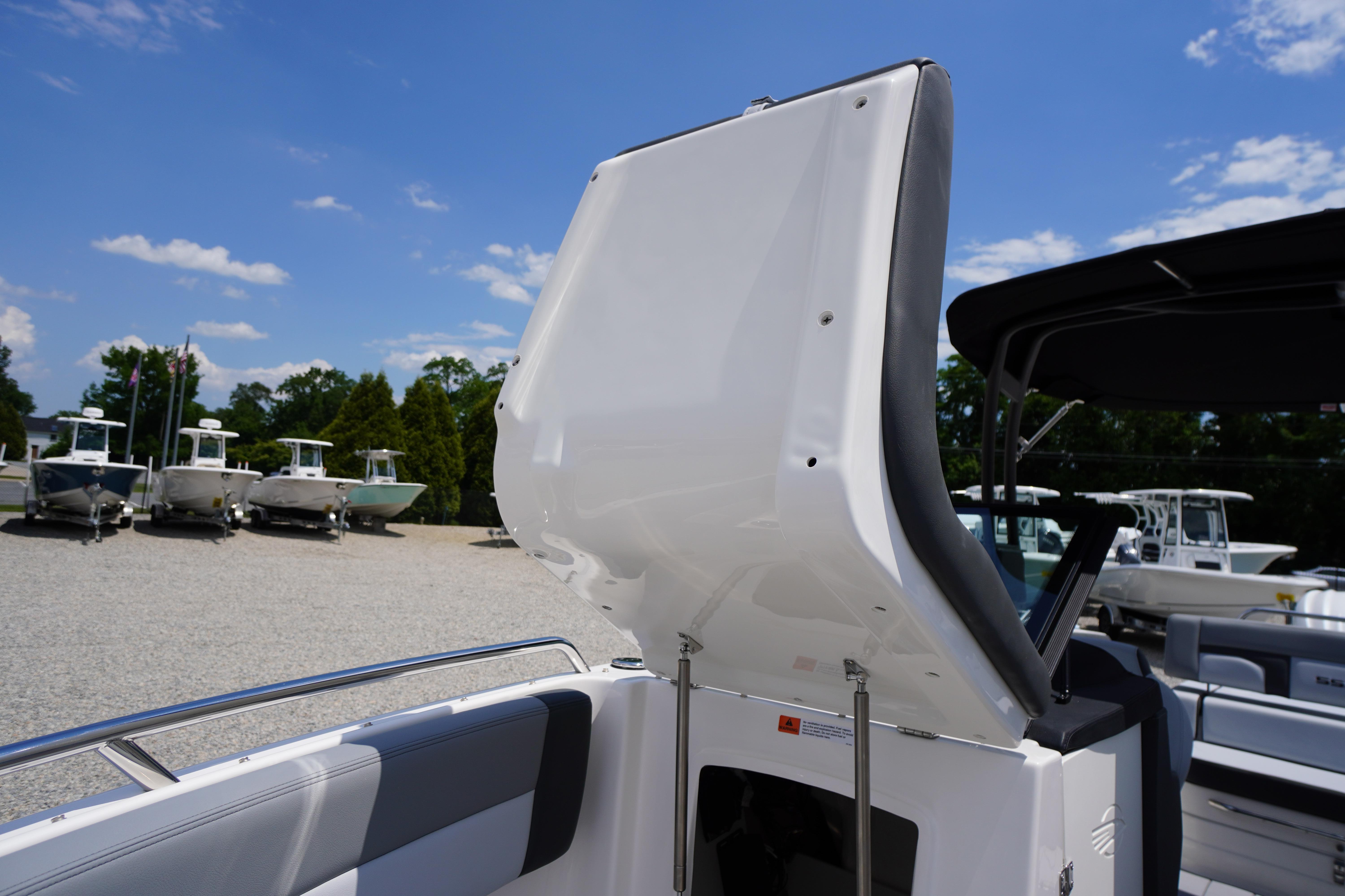 2026 Chaparral SSX 4 boat interior with open storage compartment, sunny day.