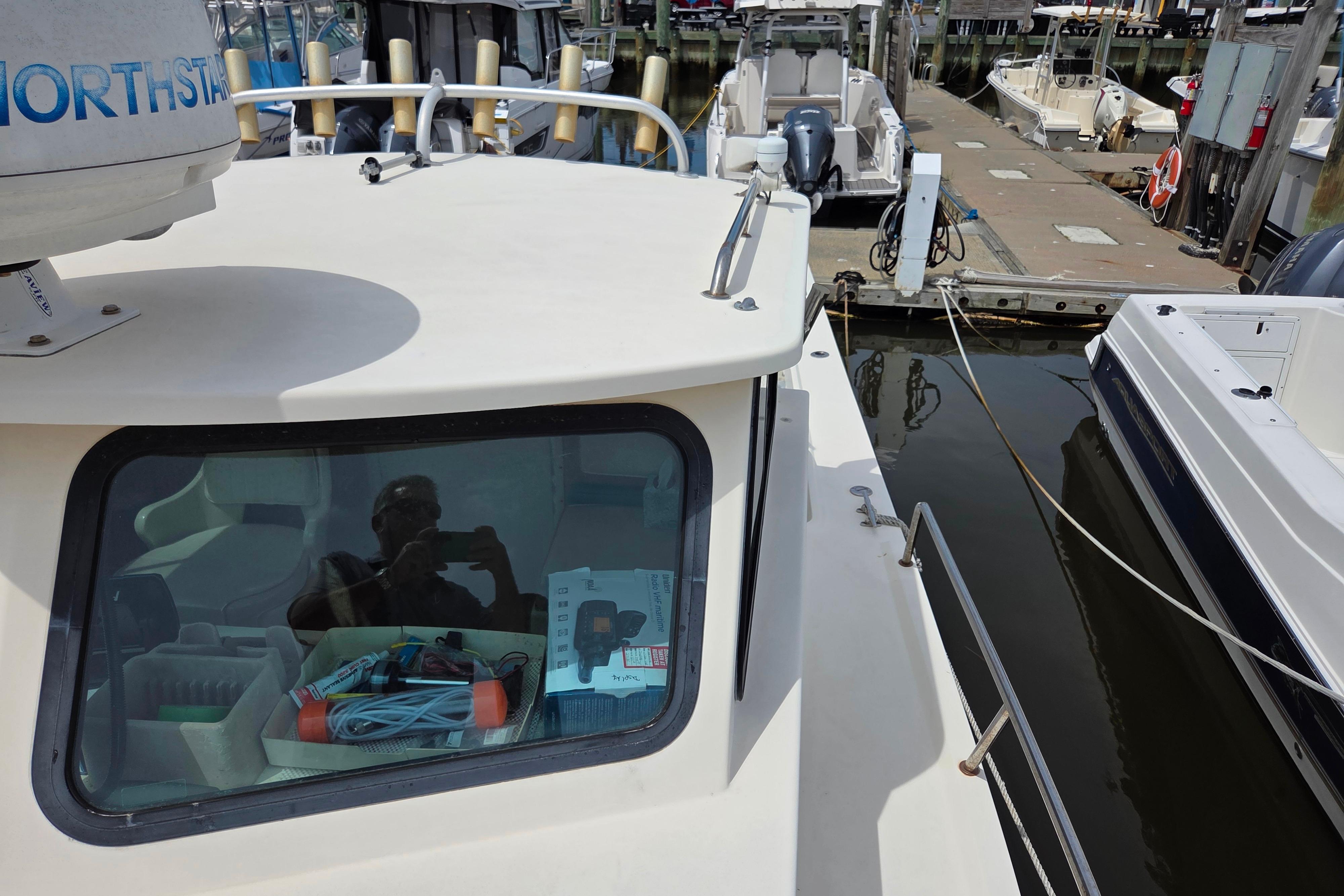 2002 Parker 2520 Deep Vee Sport Cabin docked, featuring cabin window and marine equipment.