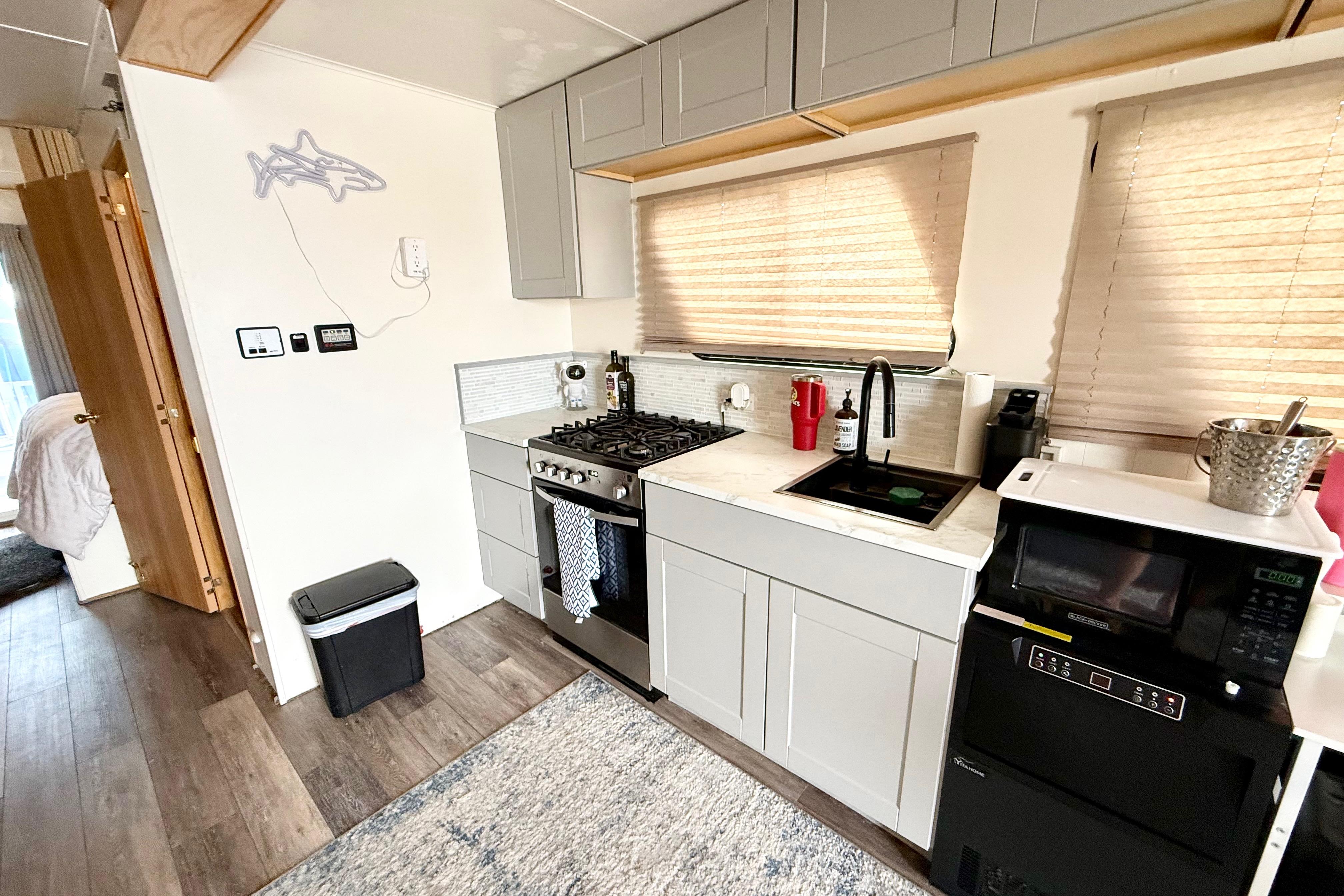 Modern kitchen interior in 2006 Myacht 4313 houseboat, featuring stove, sink, and microwave.