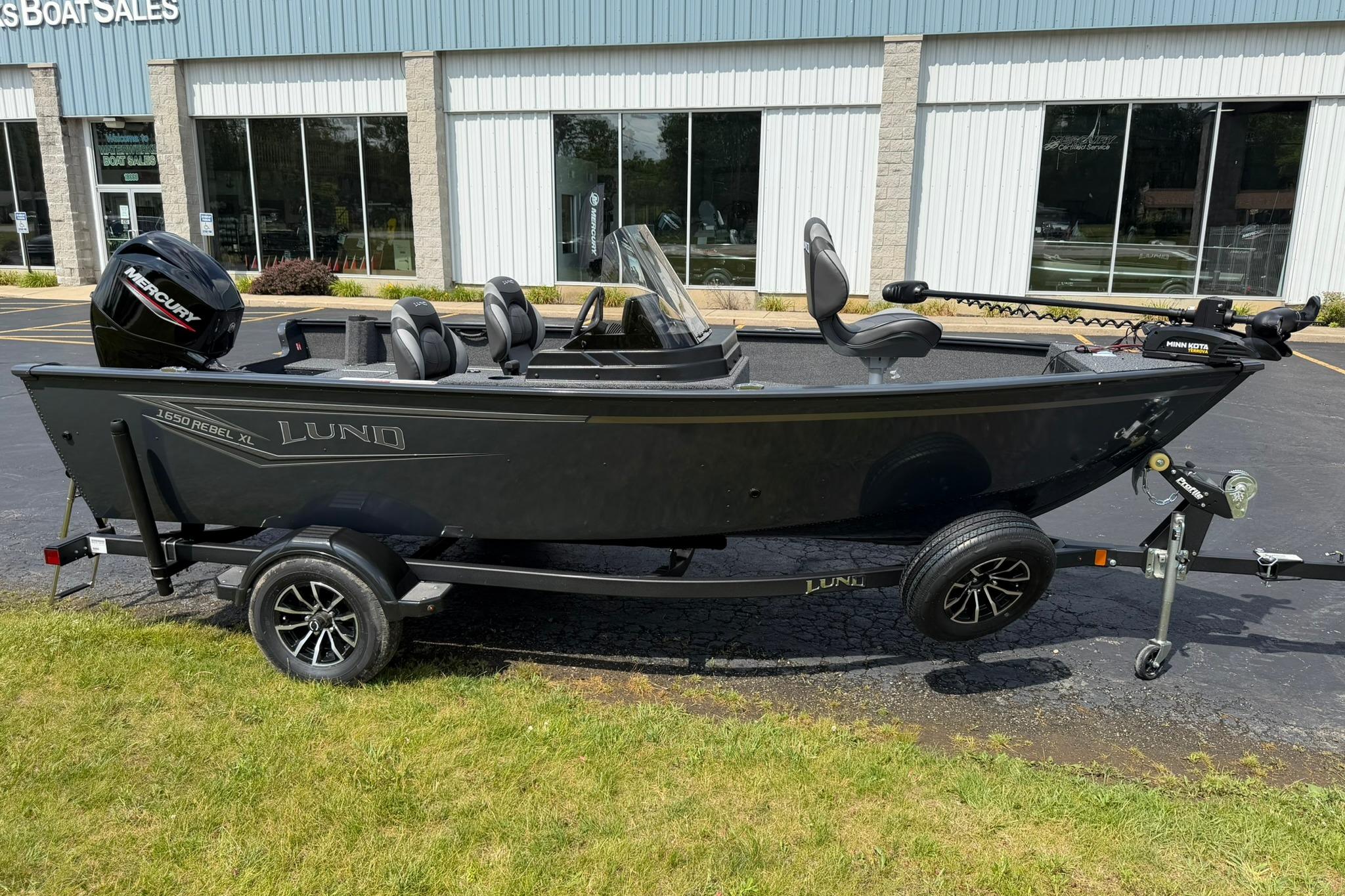 2027 Lund 1650 Rebel XL SS boat on trailer, parked outside dealership.