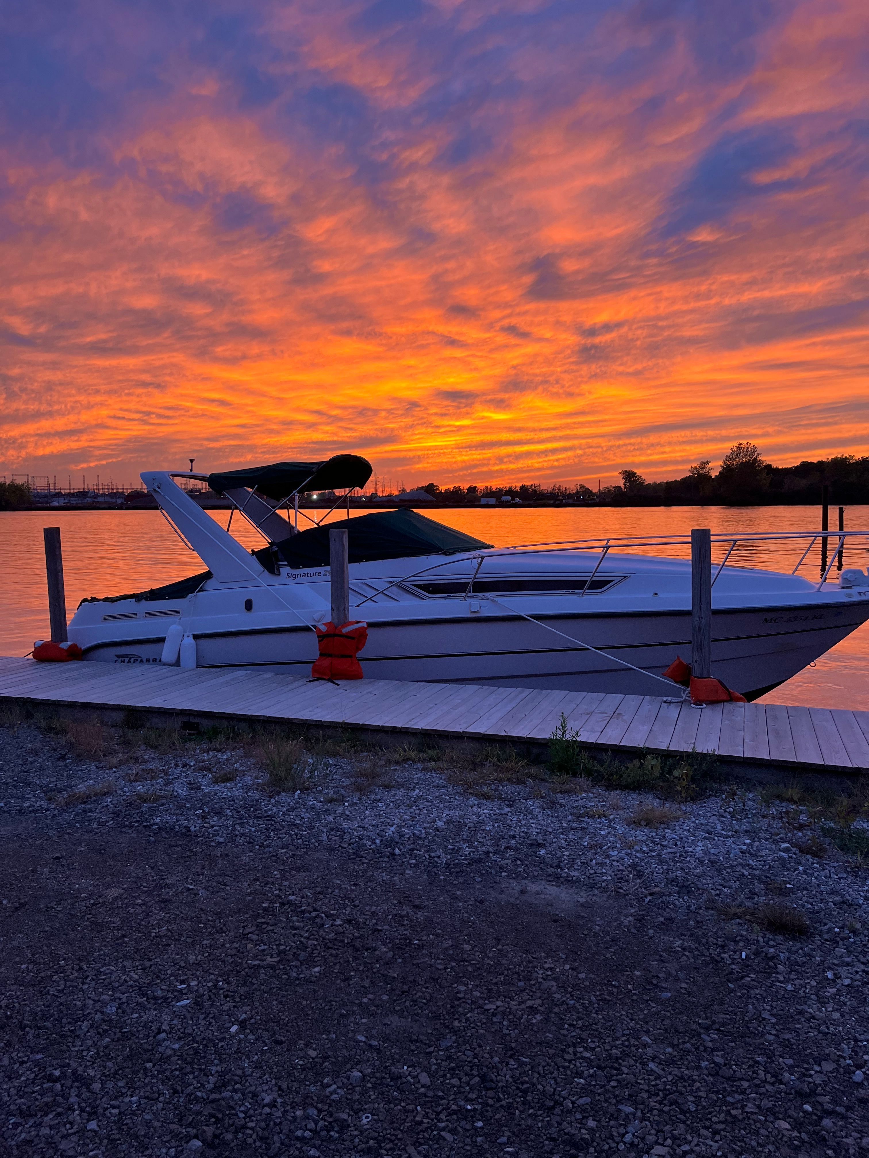 Boat docked at sunset with a vibrant sky.