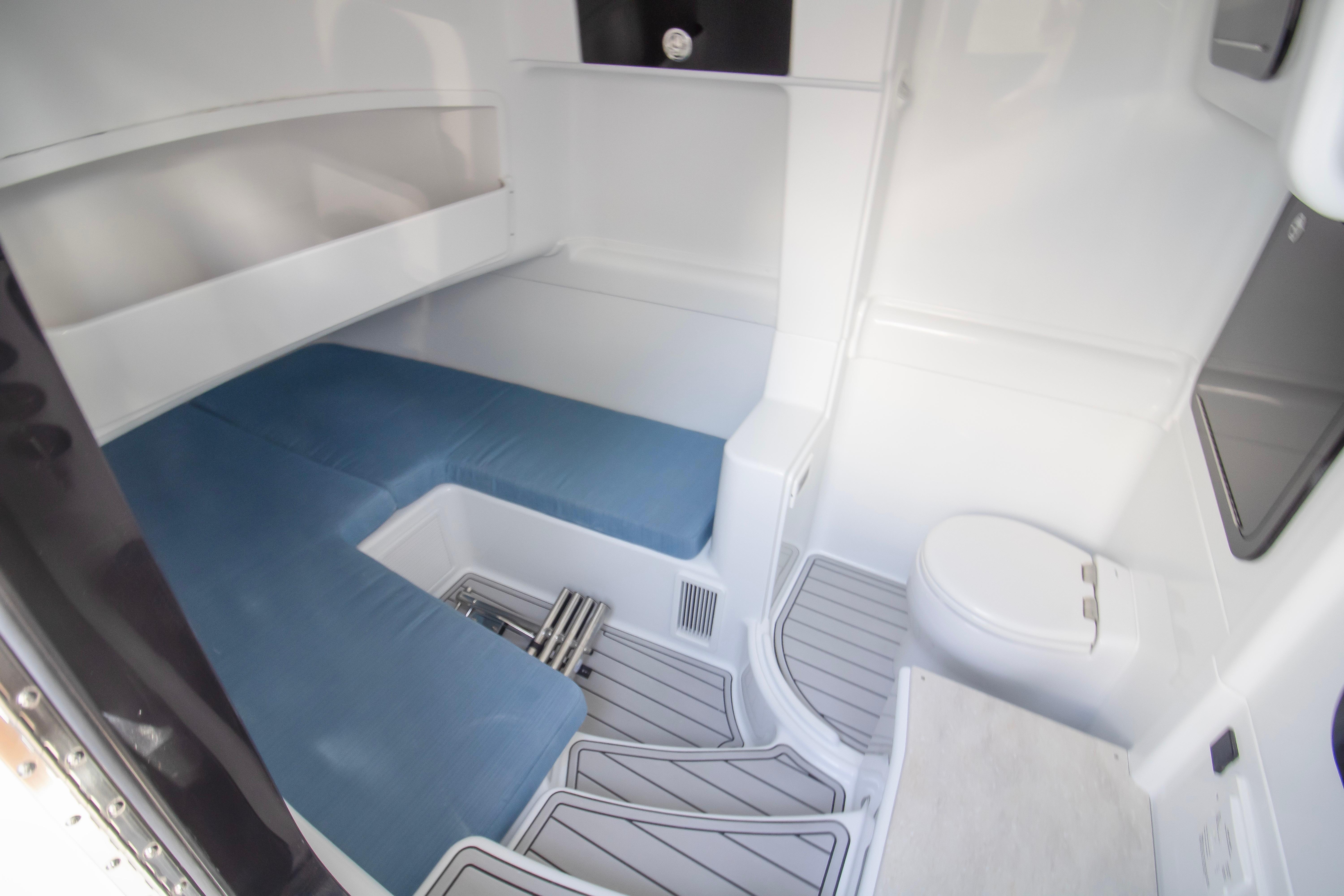 2026 Yellowfin 42 Offshore cabin interior with blue seating and compact toilet.