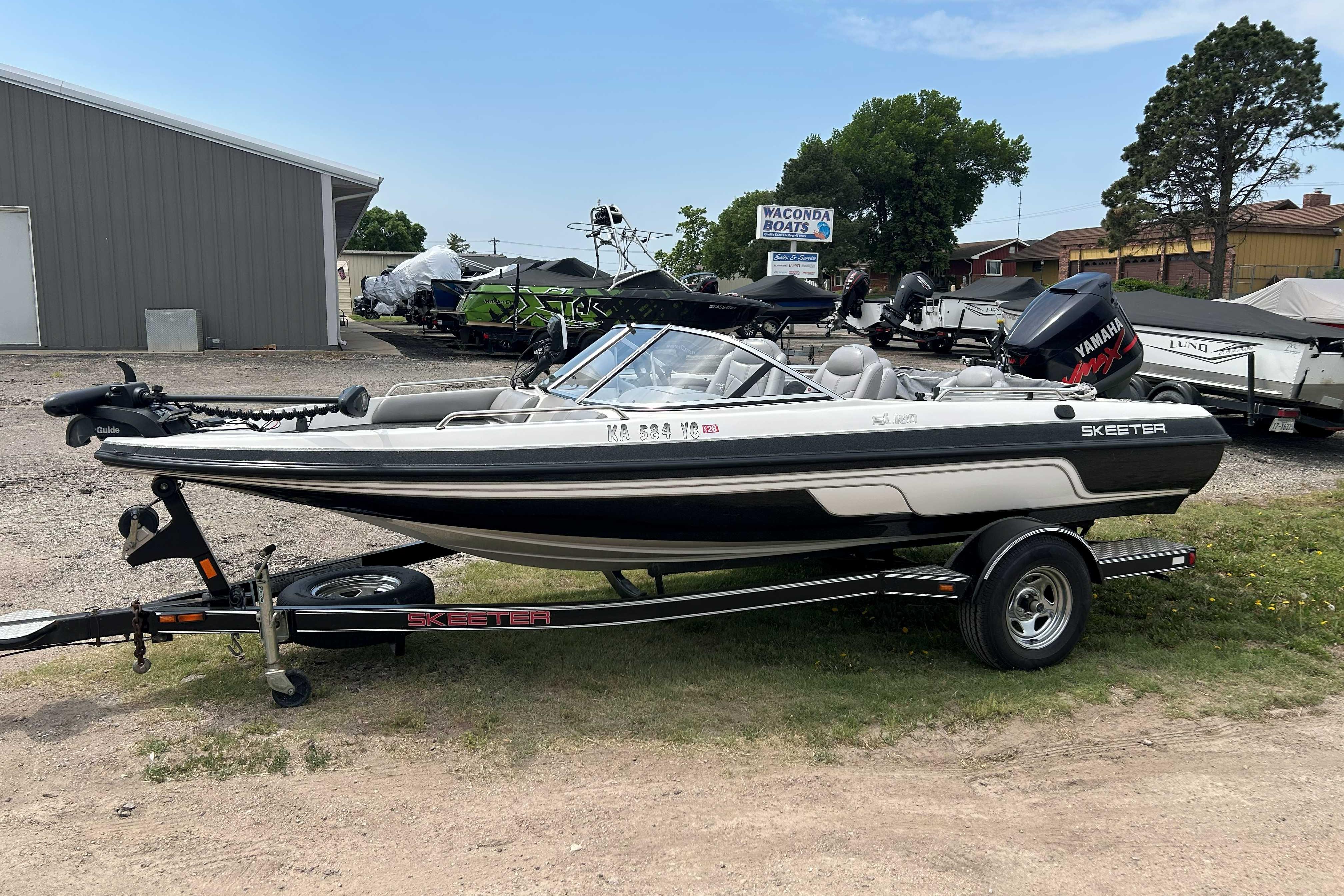 2010 Skeeter SL 180 boat on trailer, parked outdoors near dealership.
