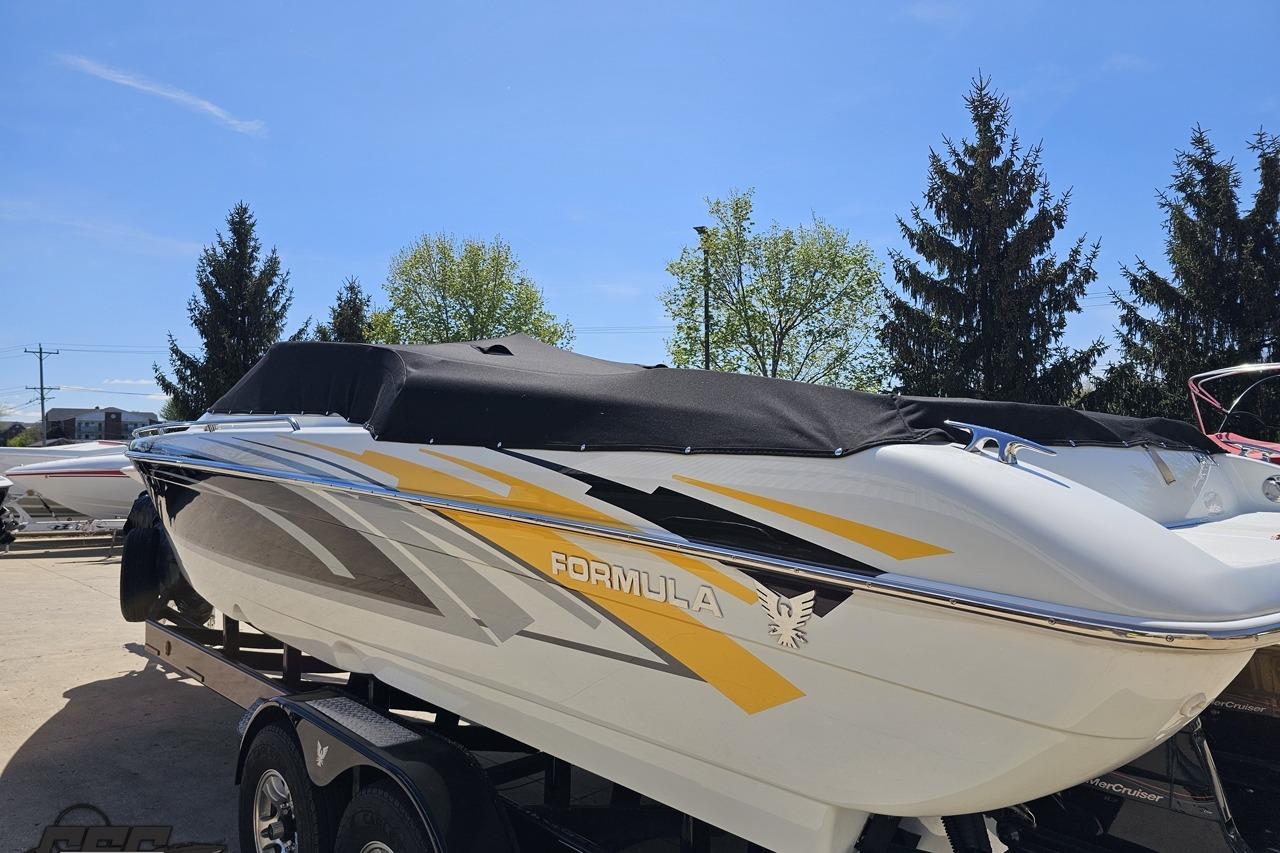 2014 Formula 292 FASTech boat with cover, parked on trailer, under clear blue sky.