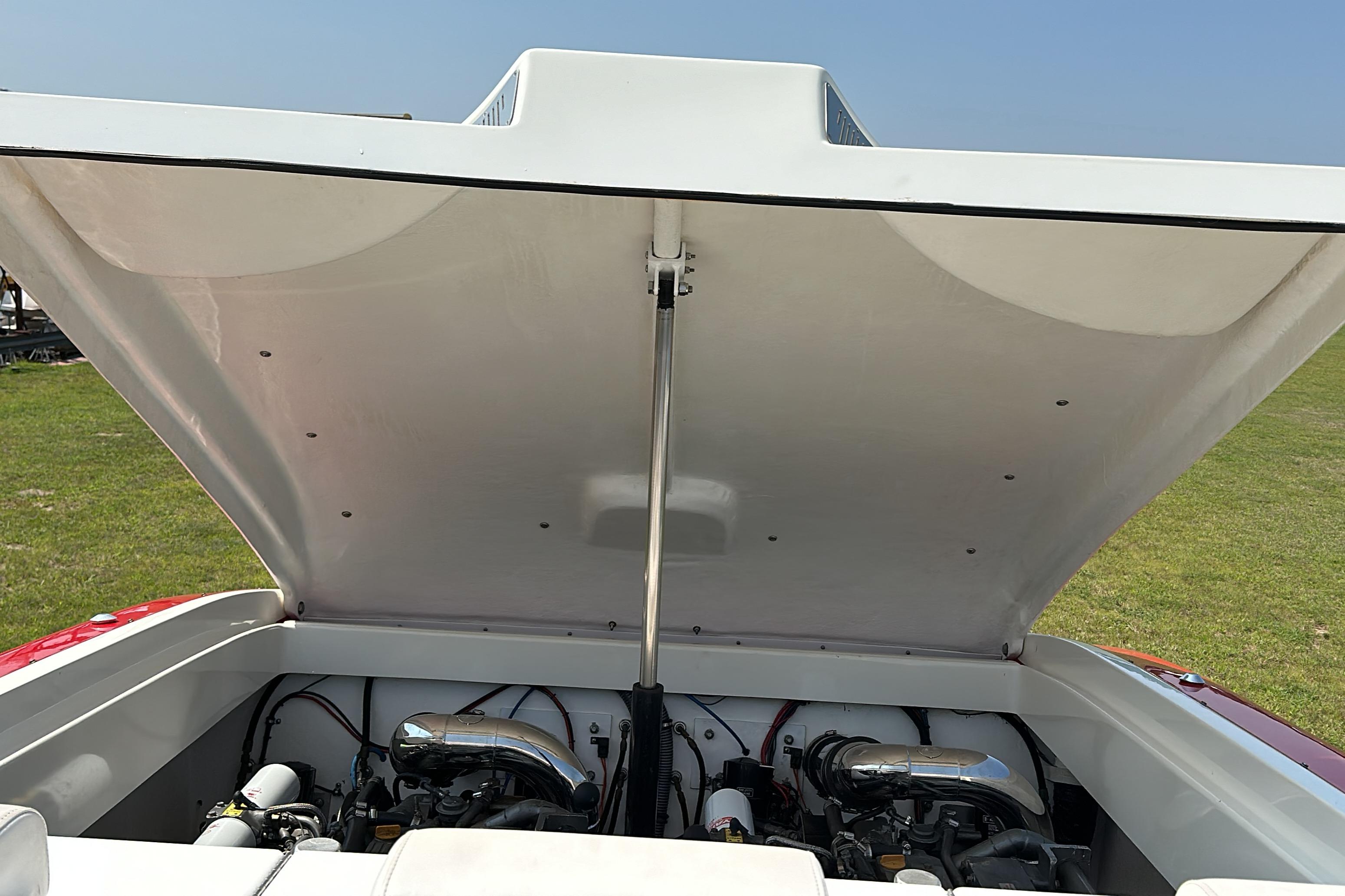2004 Hustler 388 SLINGSHOT boat engine compartment open, revealing dual engines.