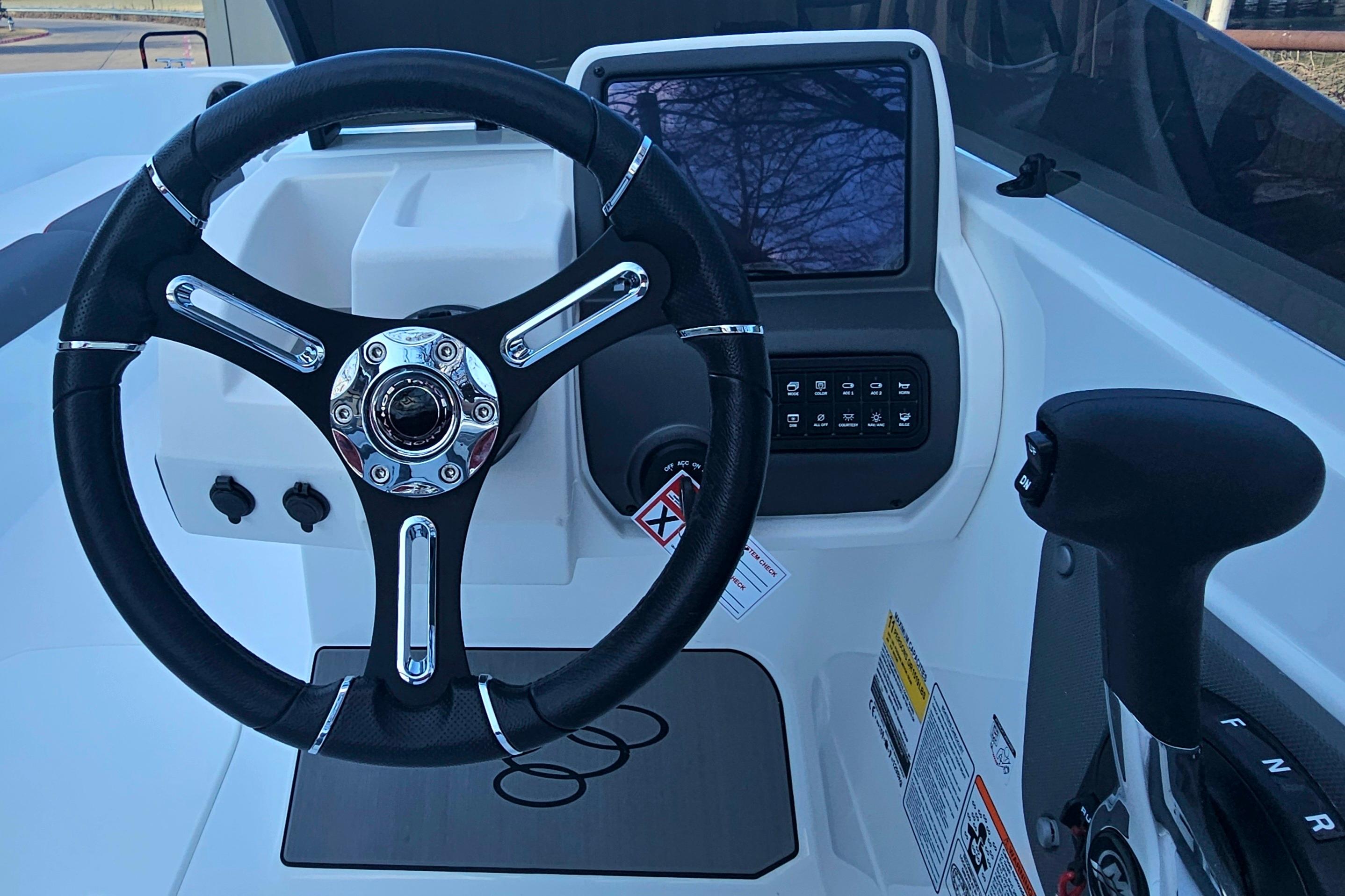 Steering wheel and dashboard of 2026 Tahoe T21 boat, featuring modern controls and display.