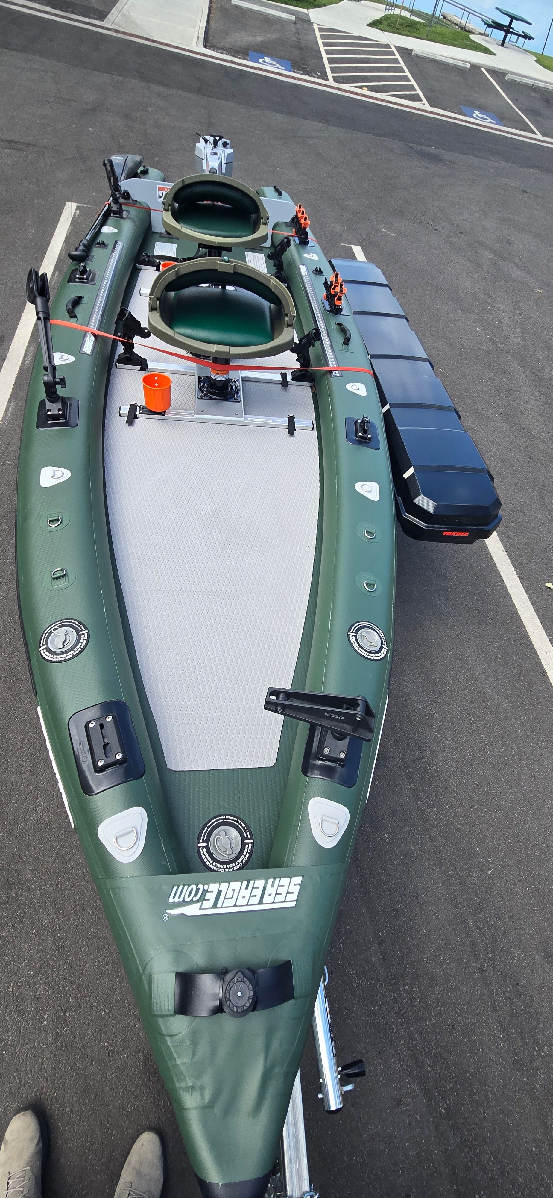 A green Sea Eagle FSK16 kayak with two seats and accessories on a parking lot.