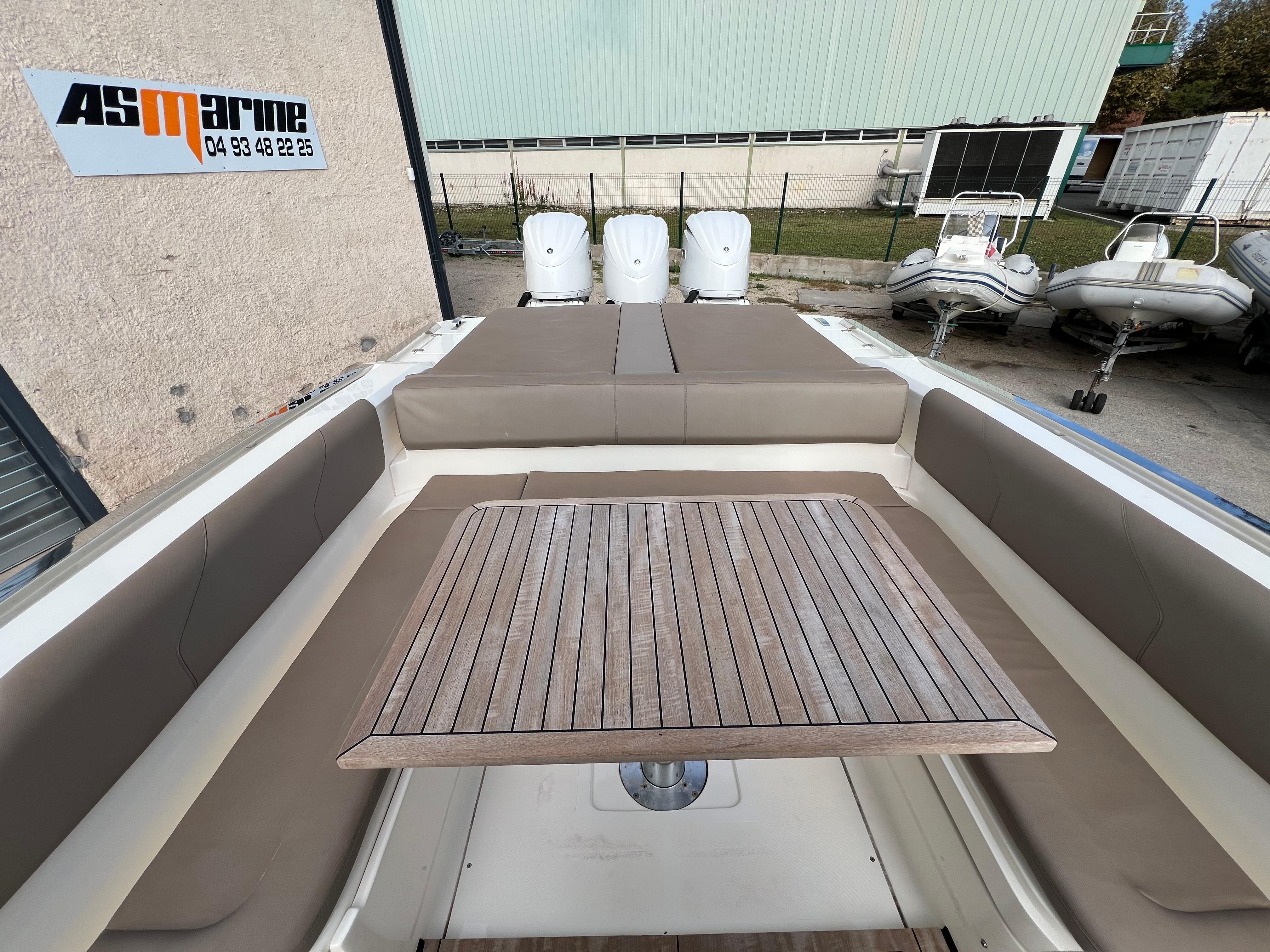 2023 Lomac GranTurismo 12.0 boat interior with wooden table and cushioned seating.