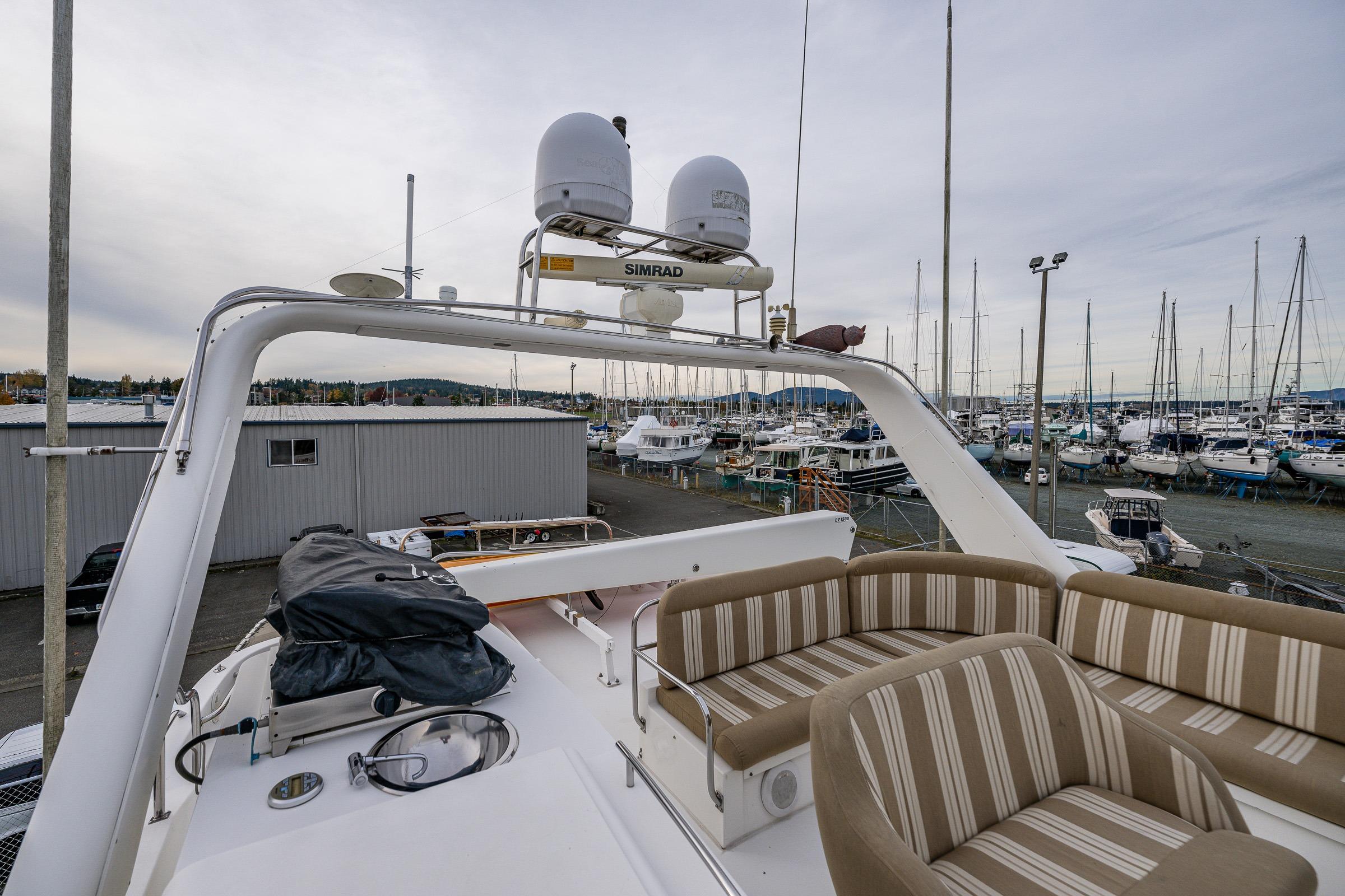 2001 Navigator Pilothouse yacht with striped seating, docked in a marina.