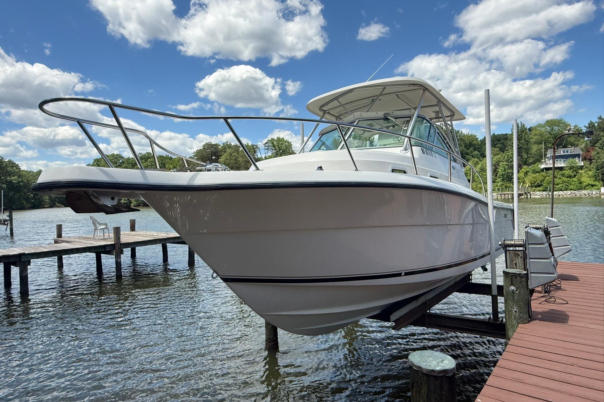 2003 Pursuit 2870 Walkaround boat docked on a sunny day with blue skies.