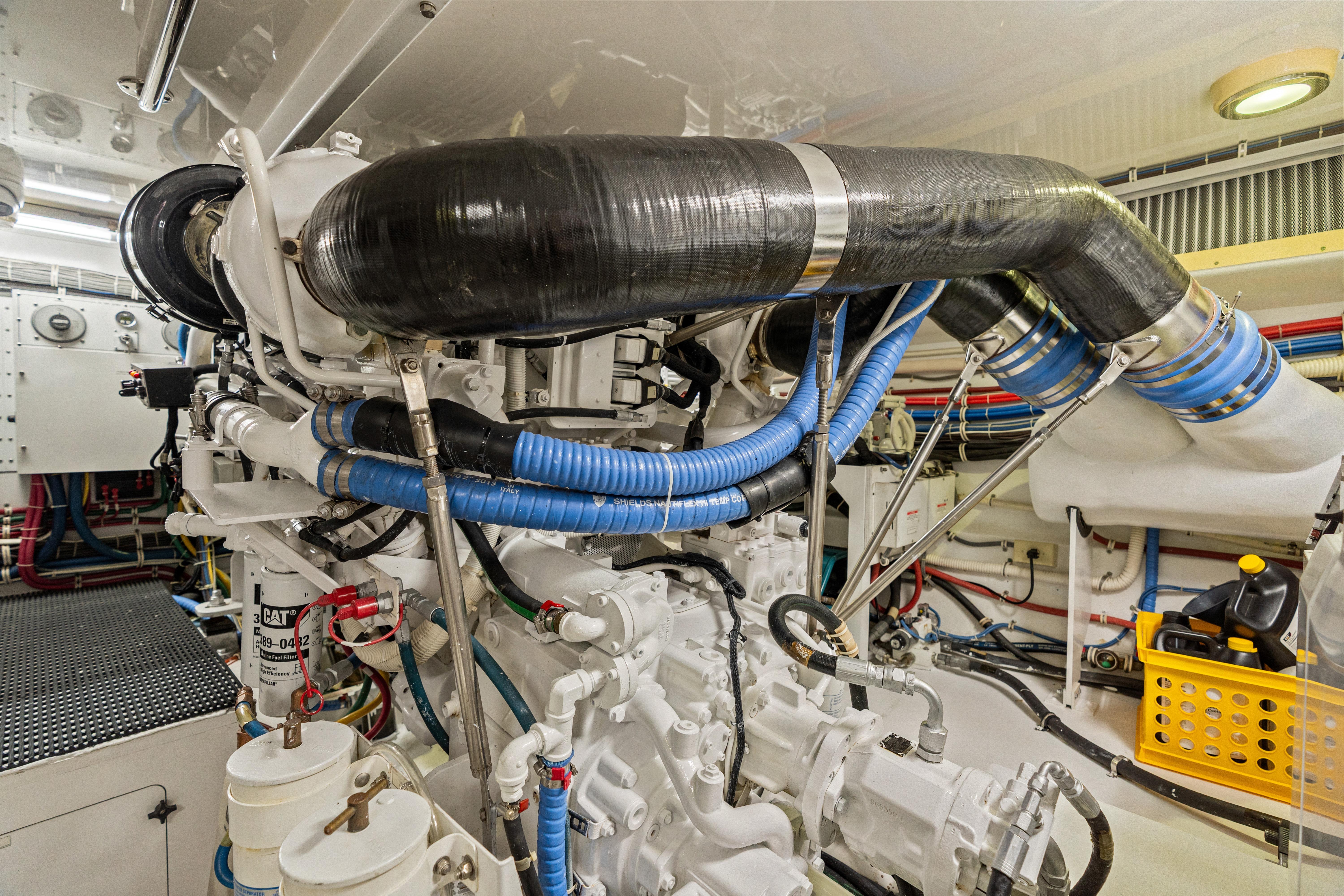 Engine room of a 2008 Hatteras 64 Motor Yacht, showcasing complex machinery and piping.