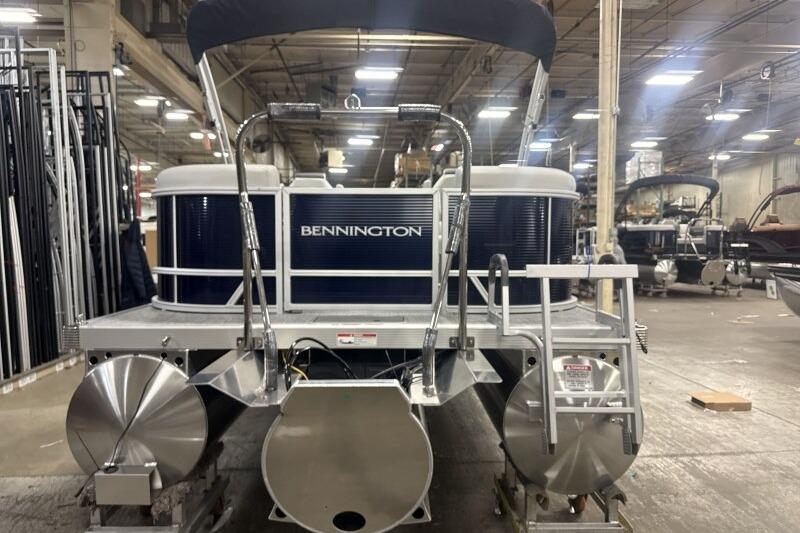 2026 Bennington 22 SSRSF pontoon boat in a factory setting, rear view.