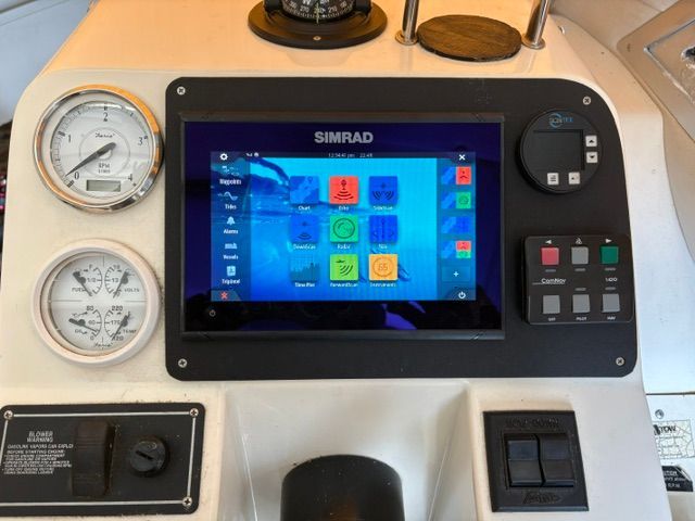 Boat dashboard with Simrad screen and gauges.