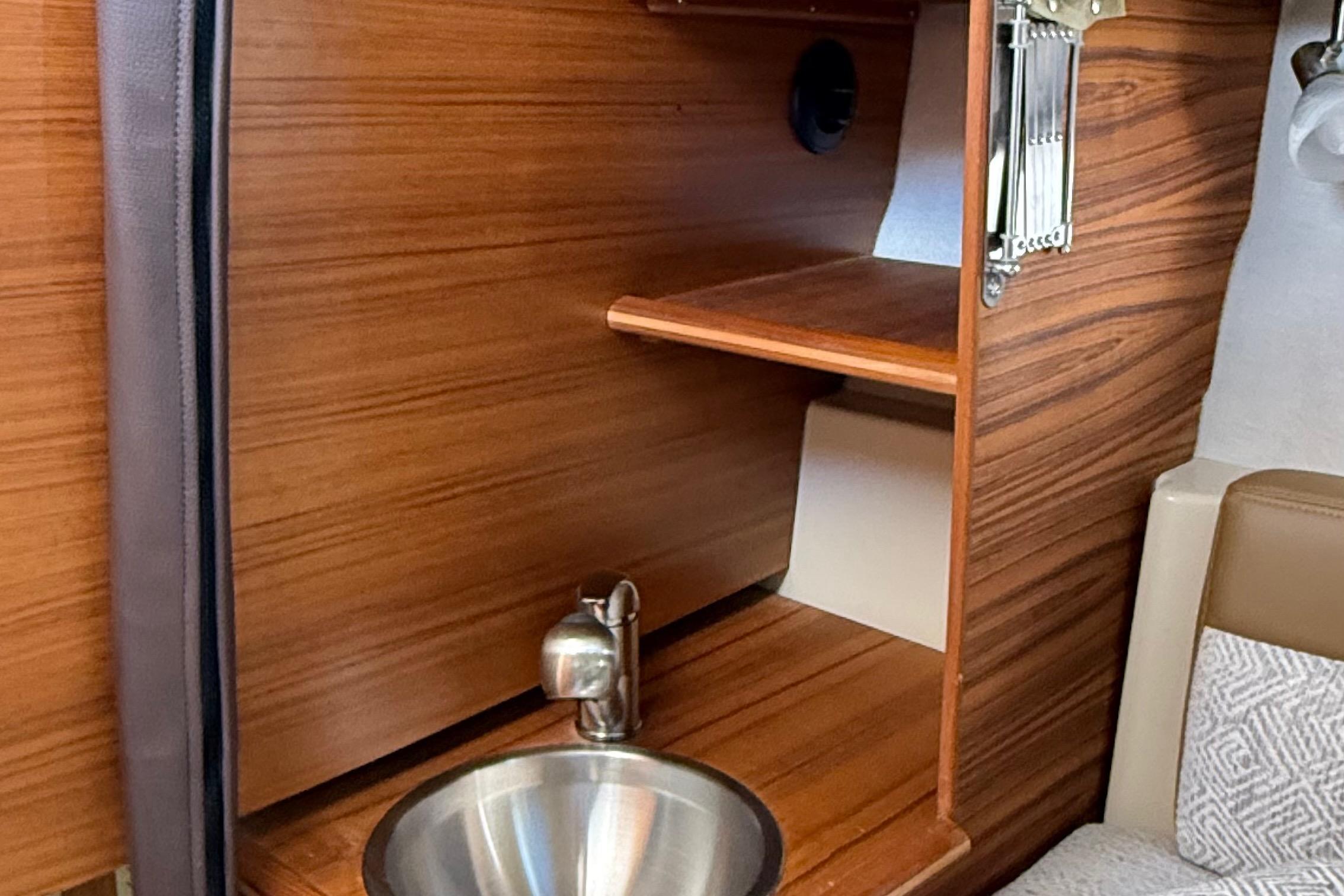 2025 Ranger Tugs R-23 interior with wooden cabinetry and stainless steel sink.
