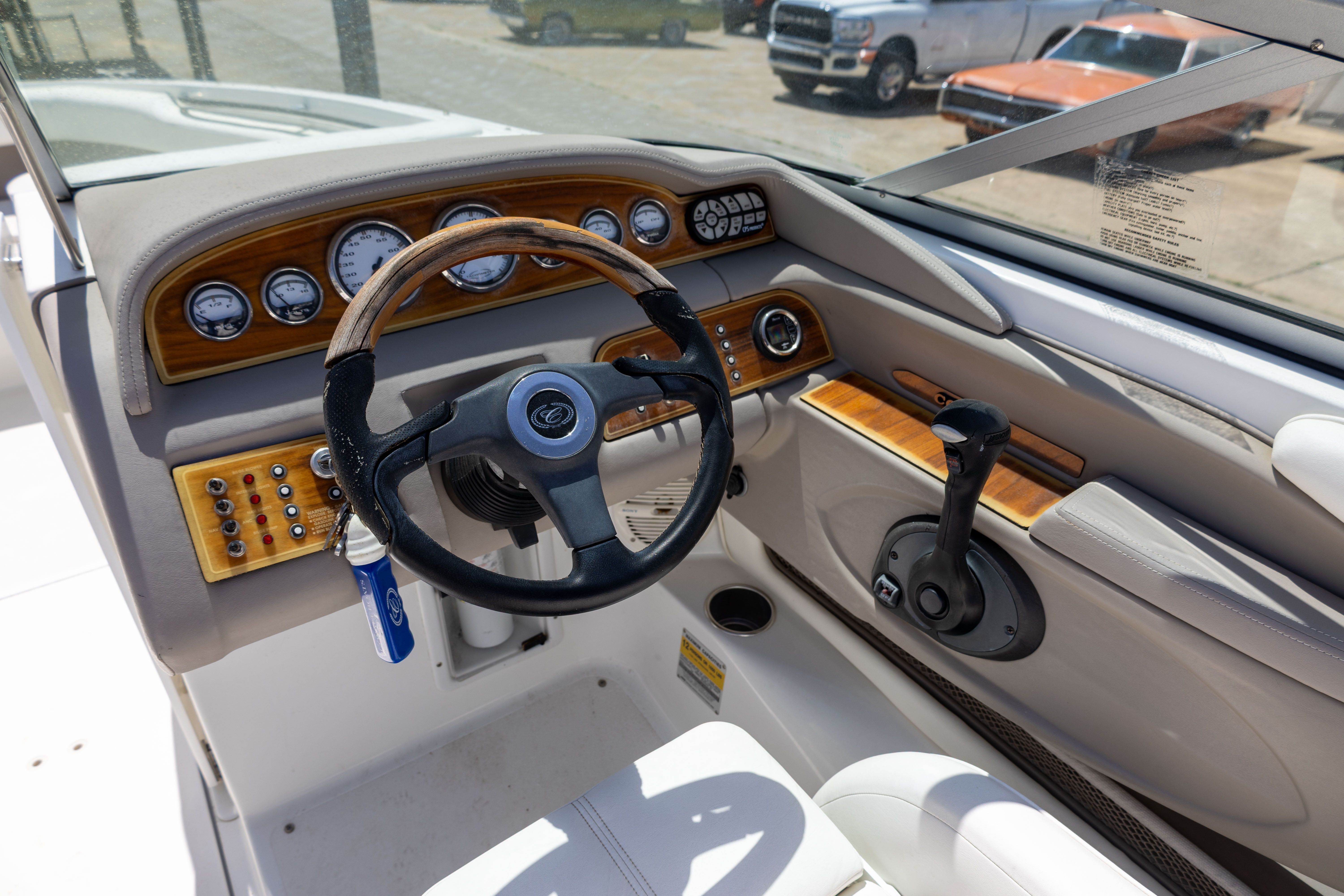 The image shows the cockpit of a 2005 Cobalt 226 boat with a wooden steering wheel.