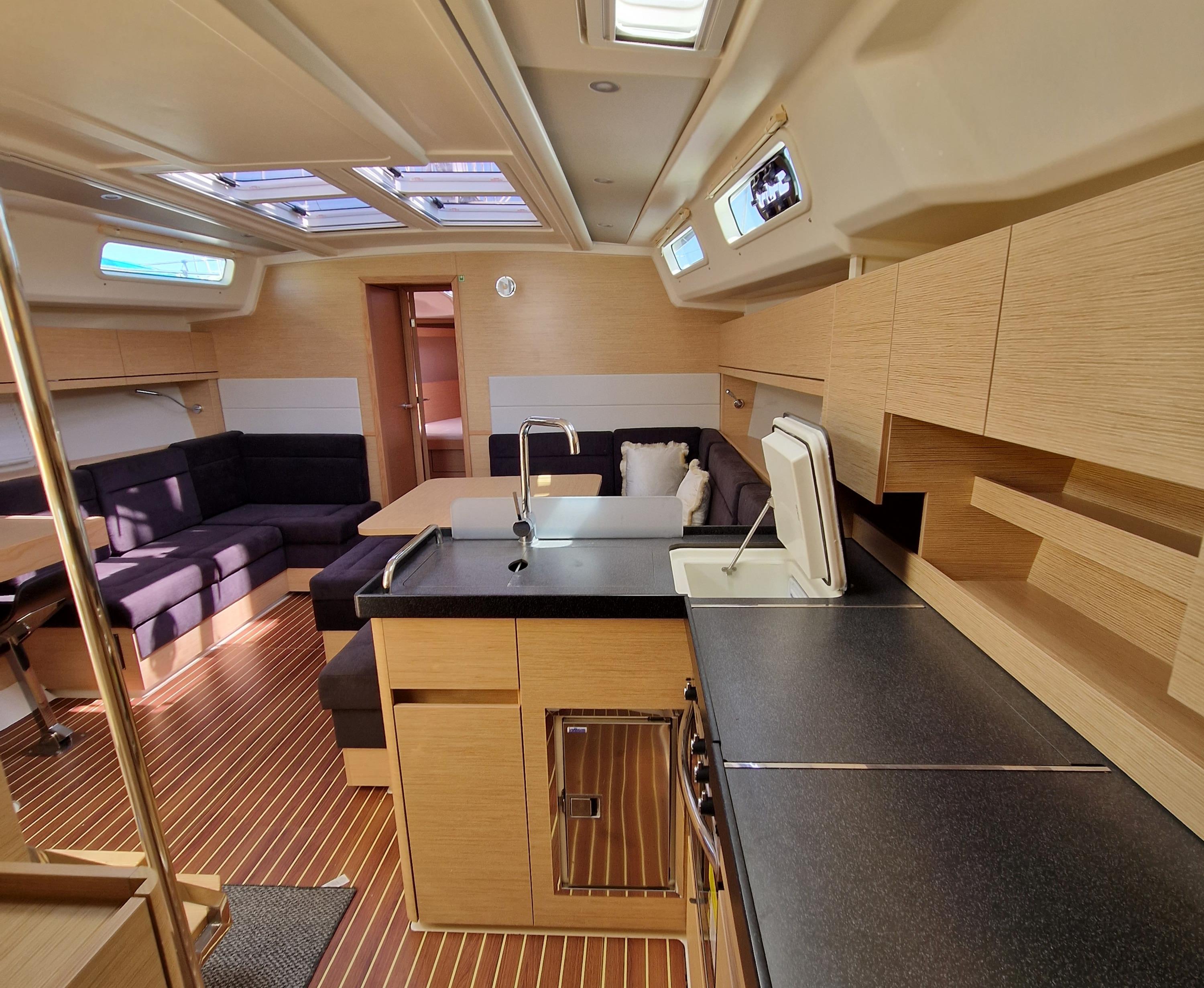 Luxurious interior of 2020 Hanse 458 yacht with modern kitchen and seating area.